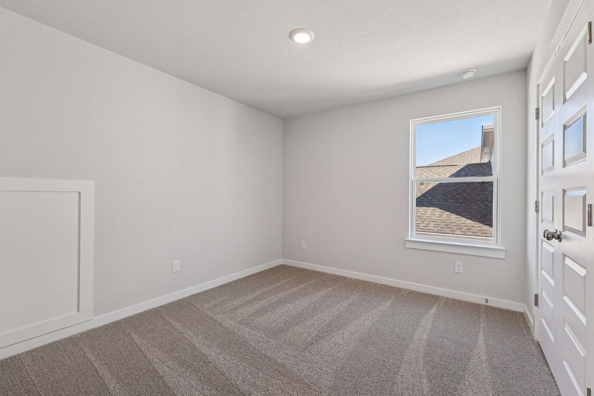 A room with white walls and a painting on the wall.
