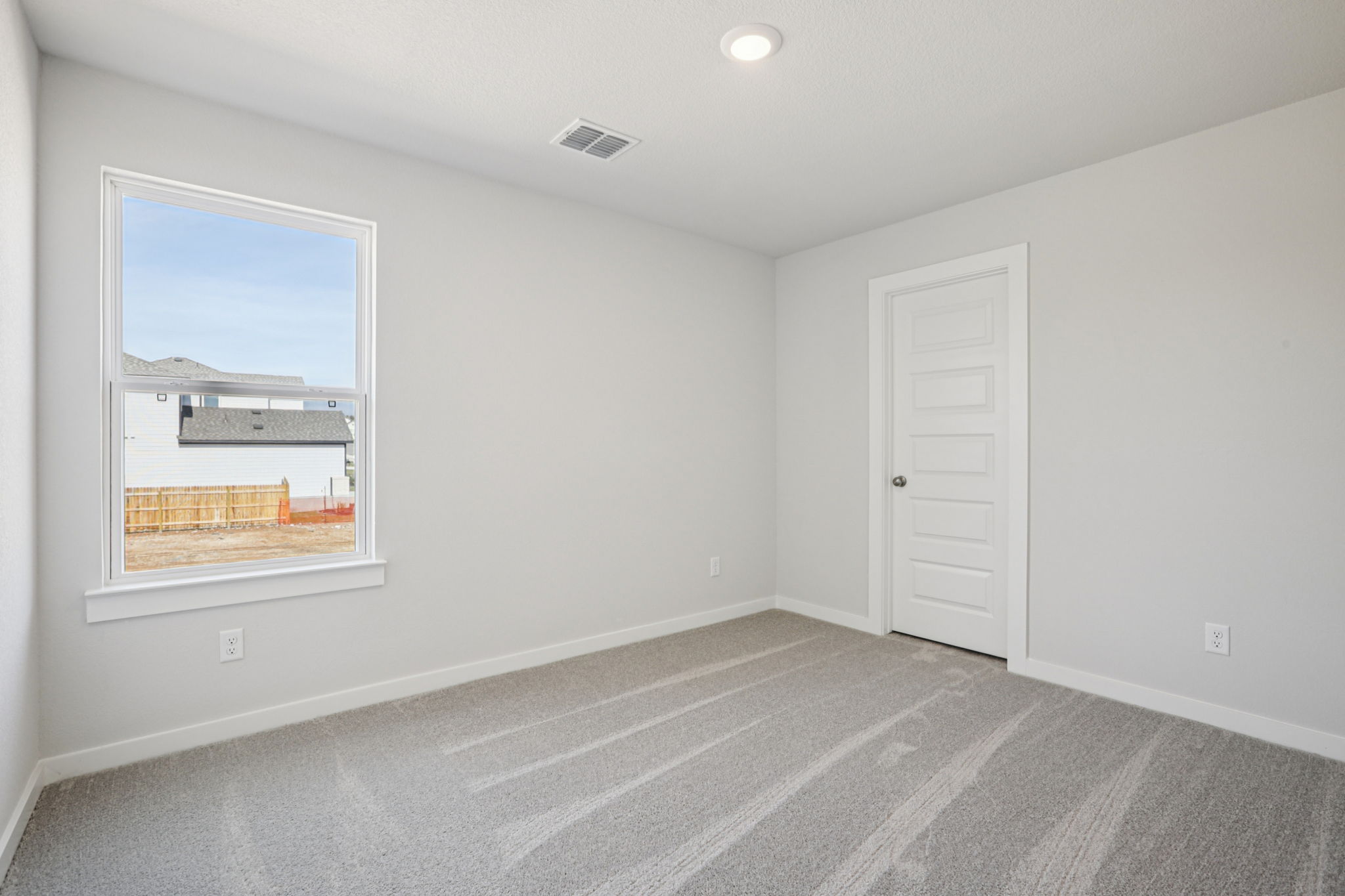 A room with a window and a rug.