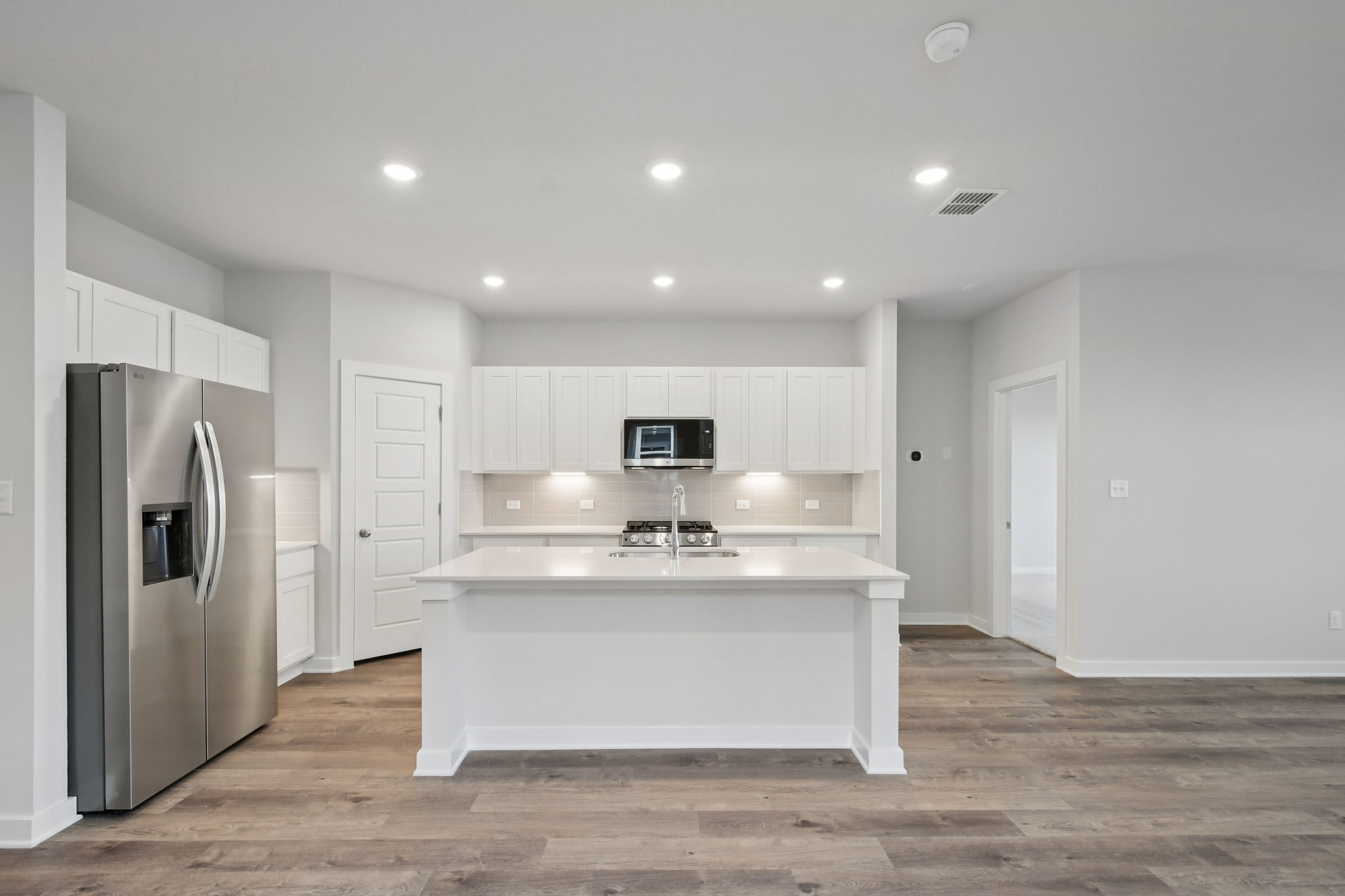 A kitchen with white cabinets.