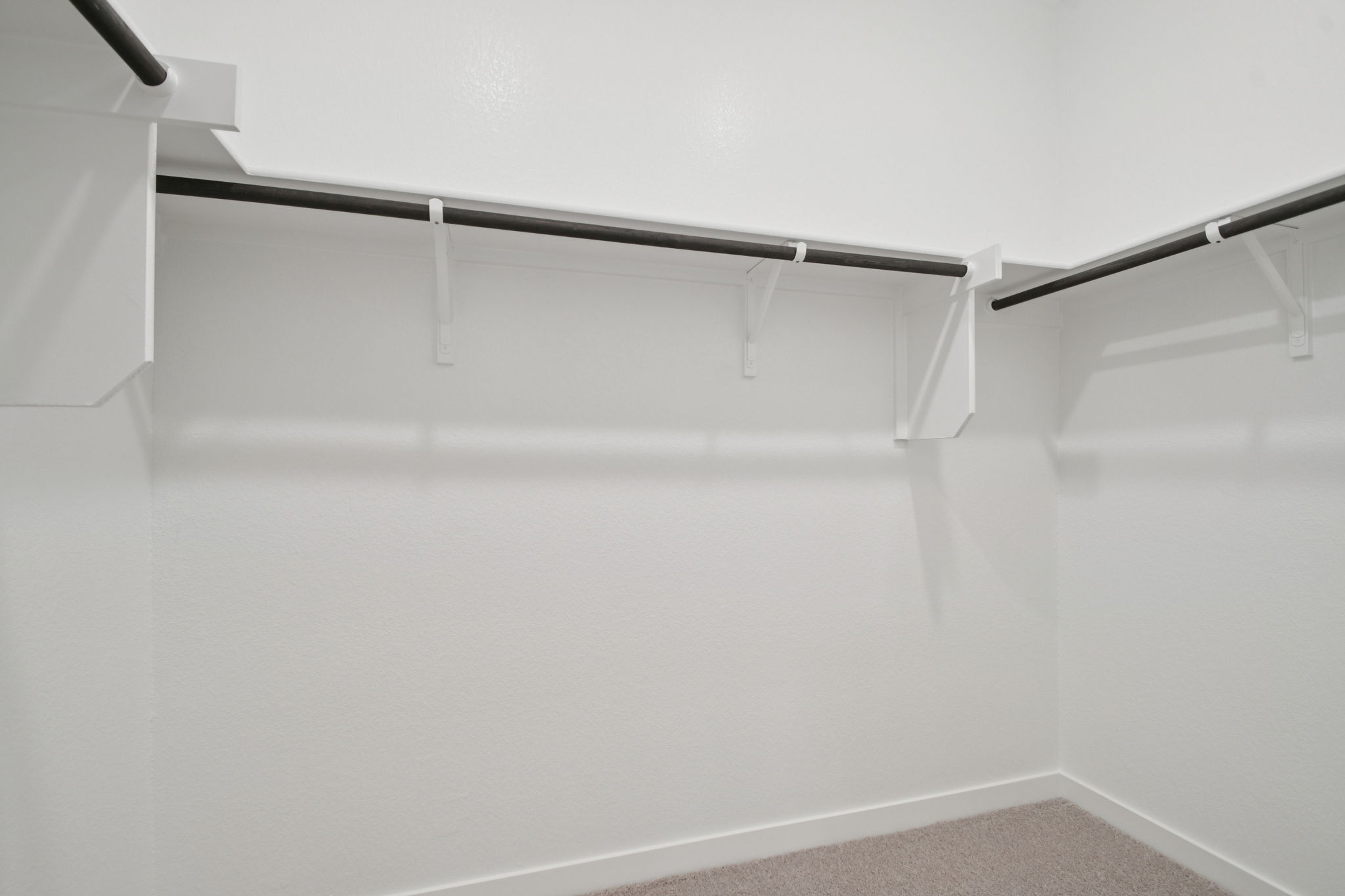 A white wall with a metal bar.