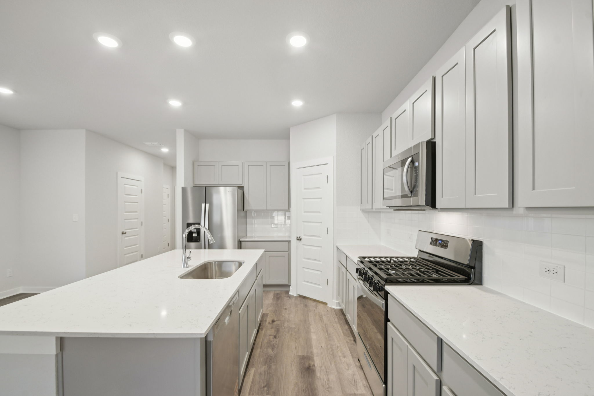 A kitchen with white cabinets.
