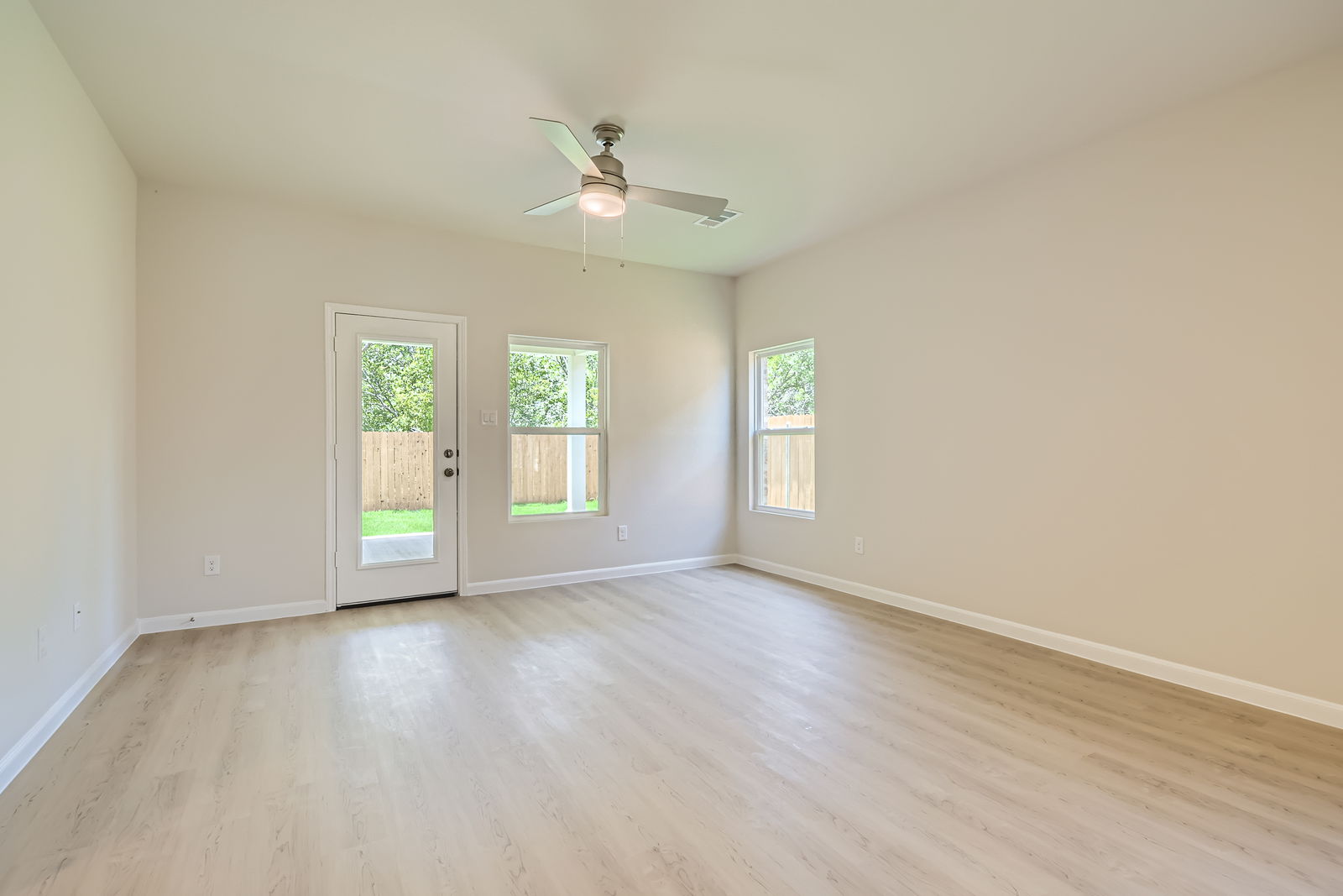 A room with a wood floor and a ceiling fan.