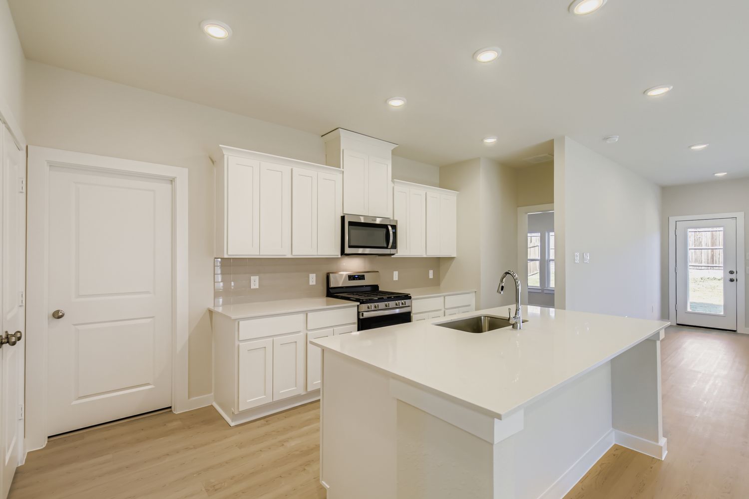 A kitchen with white cabinets.