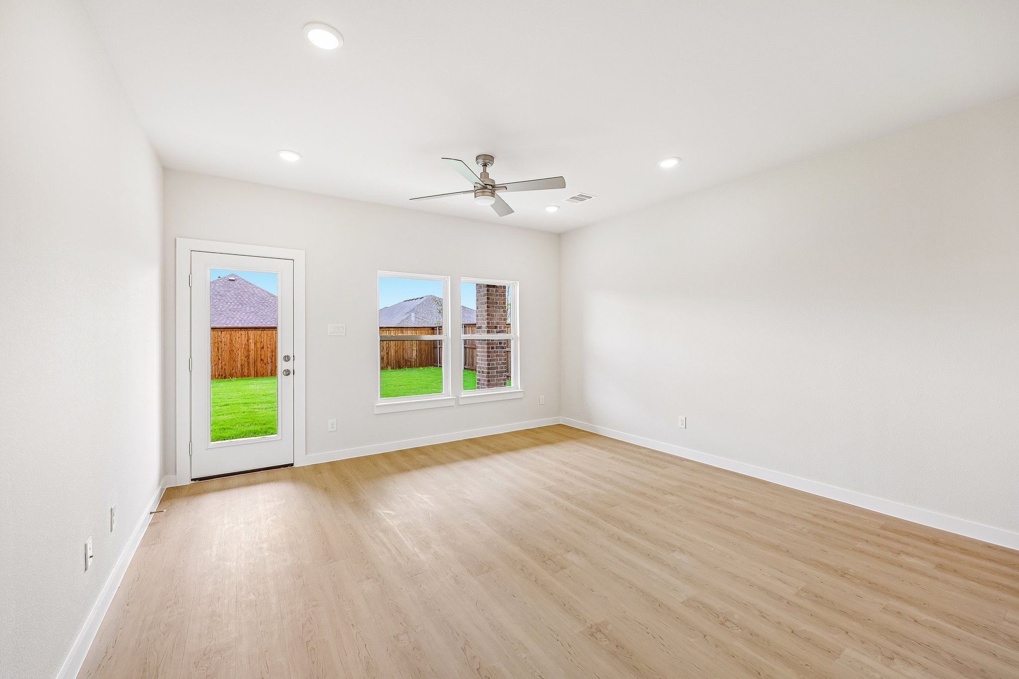 A room with a wood floor and a wood floor with a window.