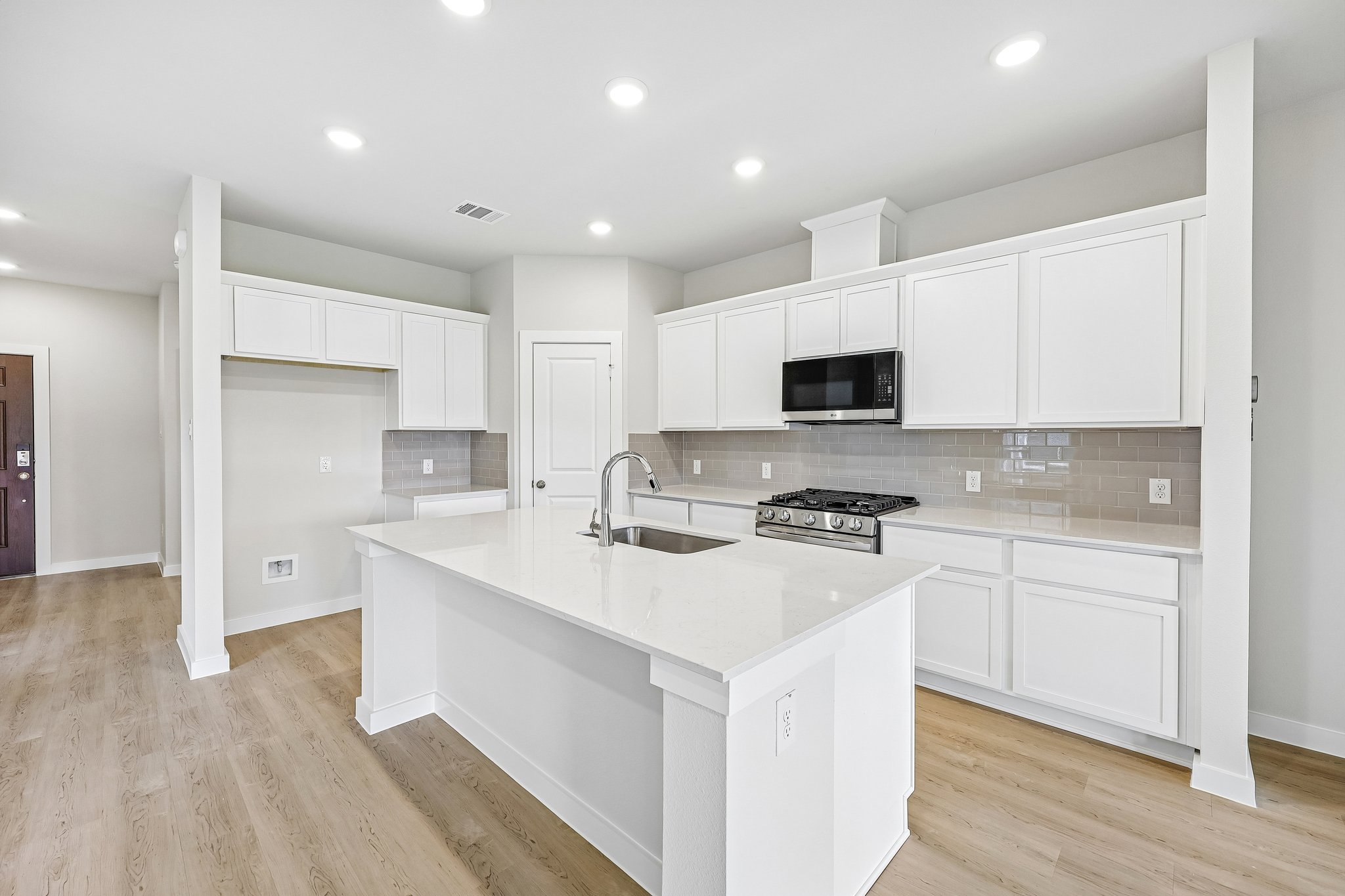 A kitchen with white cabinets.