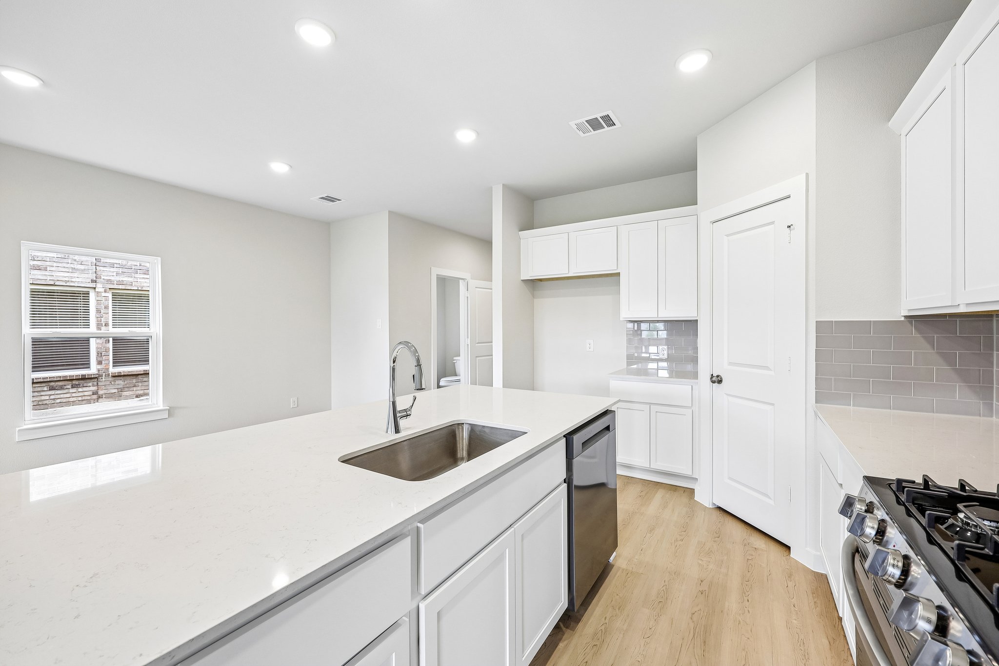 A kitchen with white cabinets.