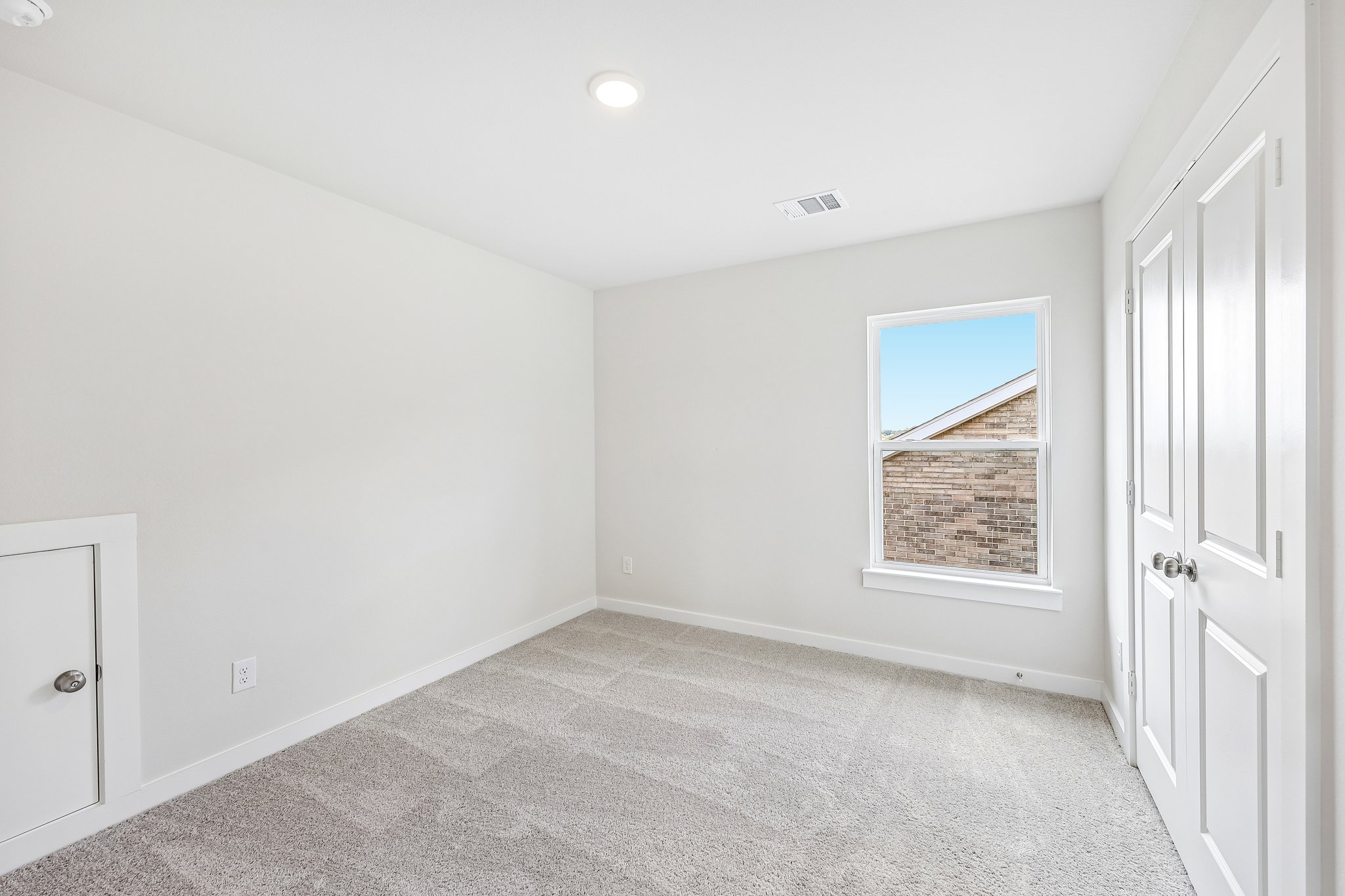 A room with white walls and a window.