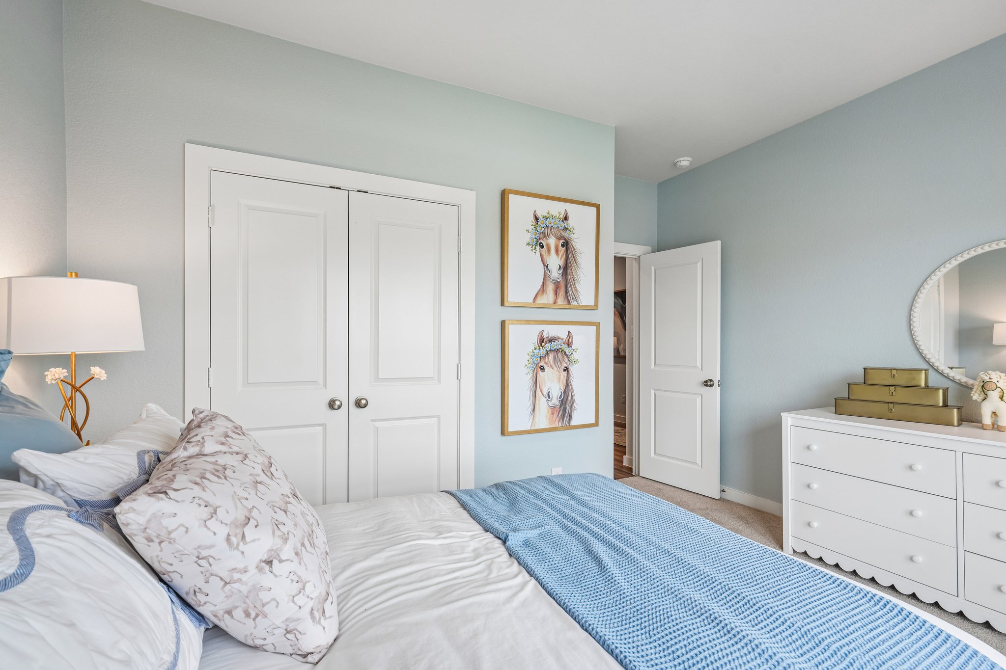 A bedroom with a bed and a mirror.