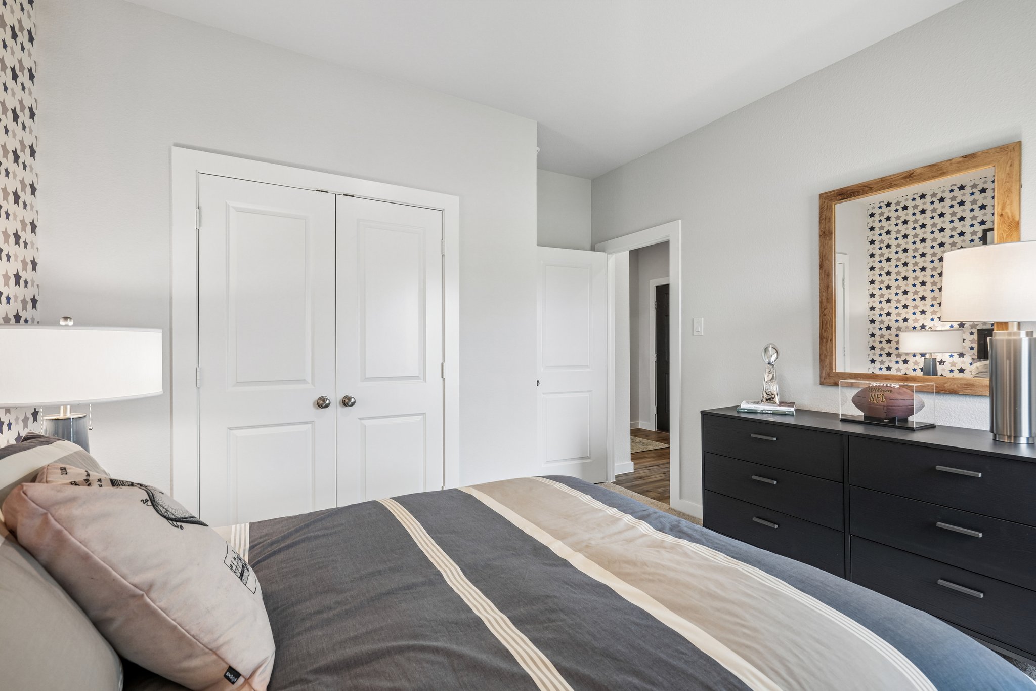 A bedroom with a bed and a mirror.