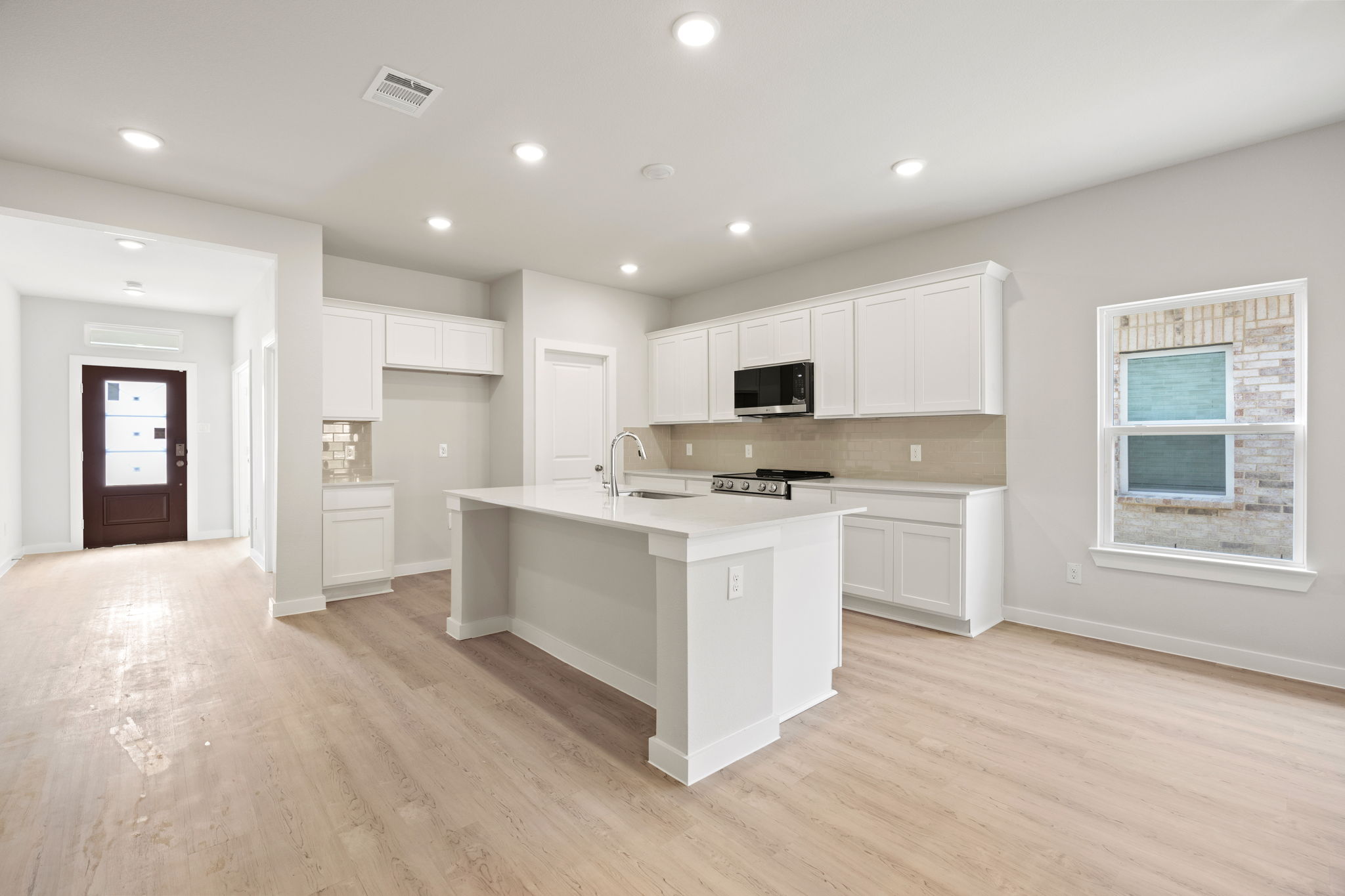 A kitchen with white cabinets.