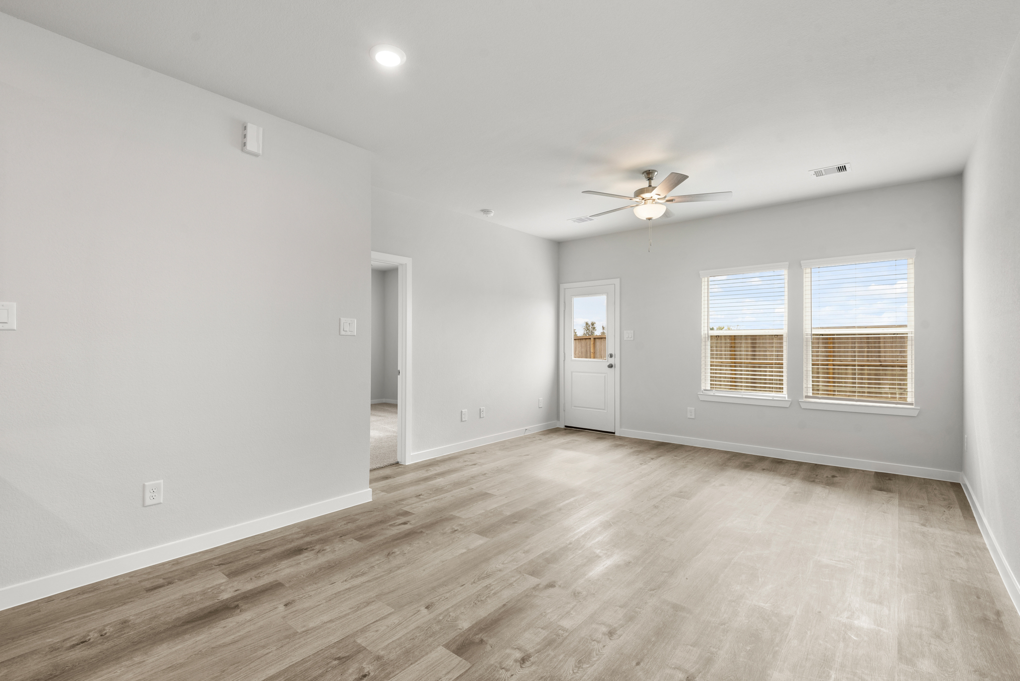 A room with a wood floor and a ceiling fan.