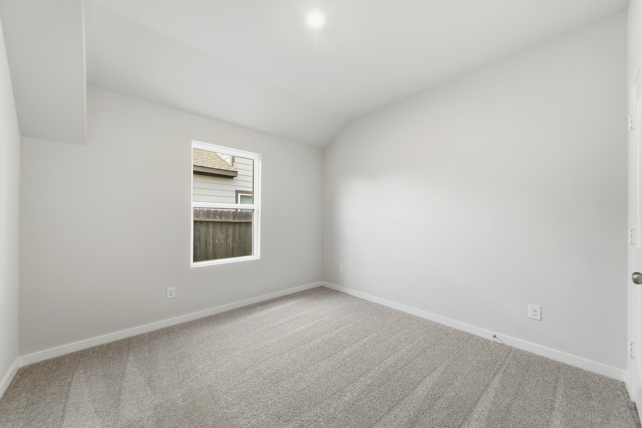 A room with a carpet and a window.