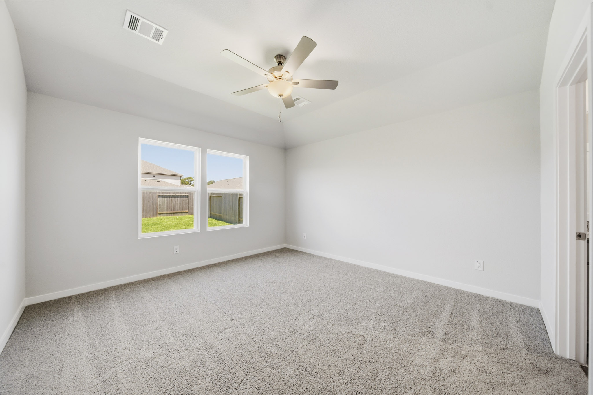 A room with a ceiling fan and a window.