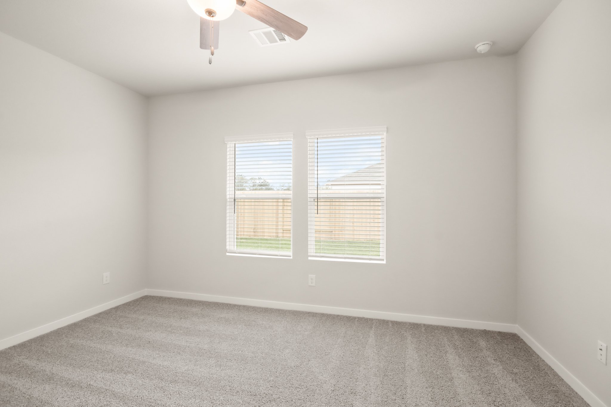 A room with a ceiling fan and a window.