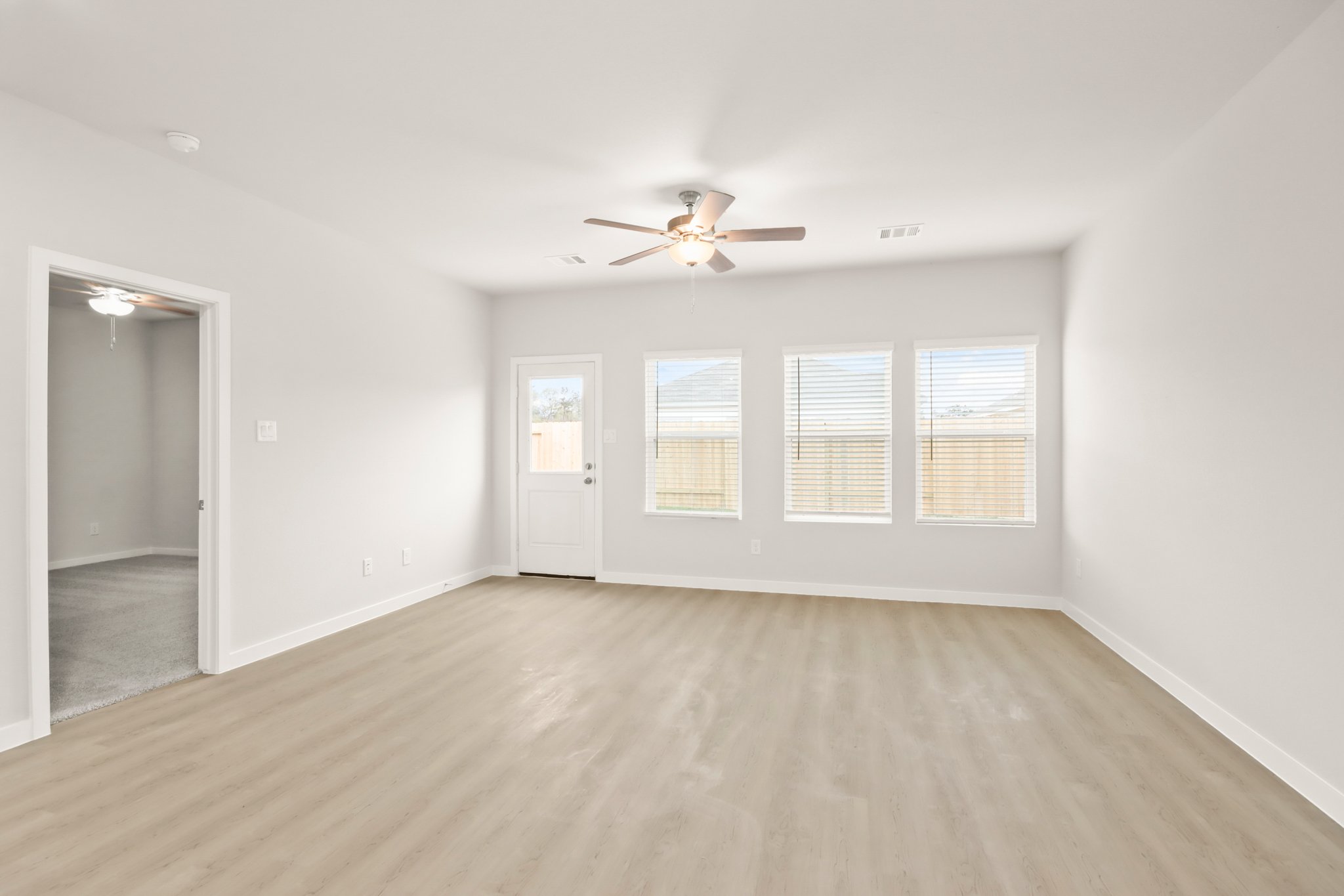 A room with a wood floor and a ceiling fan.