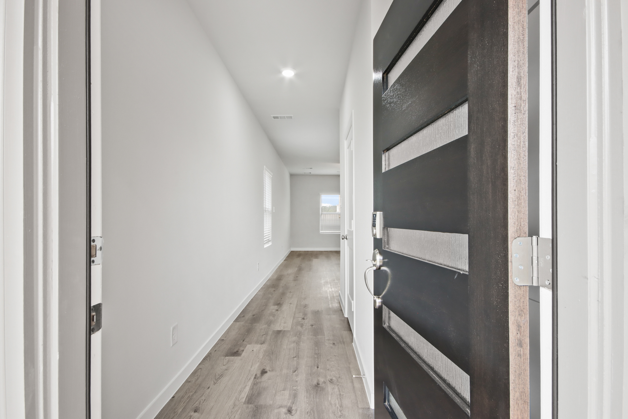 A hallway with a wood floor.