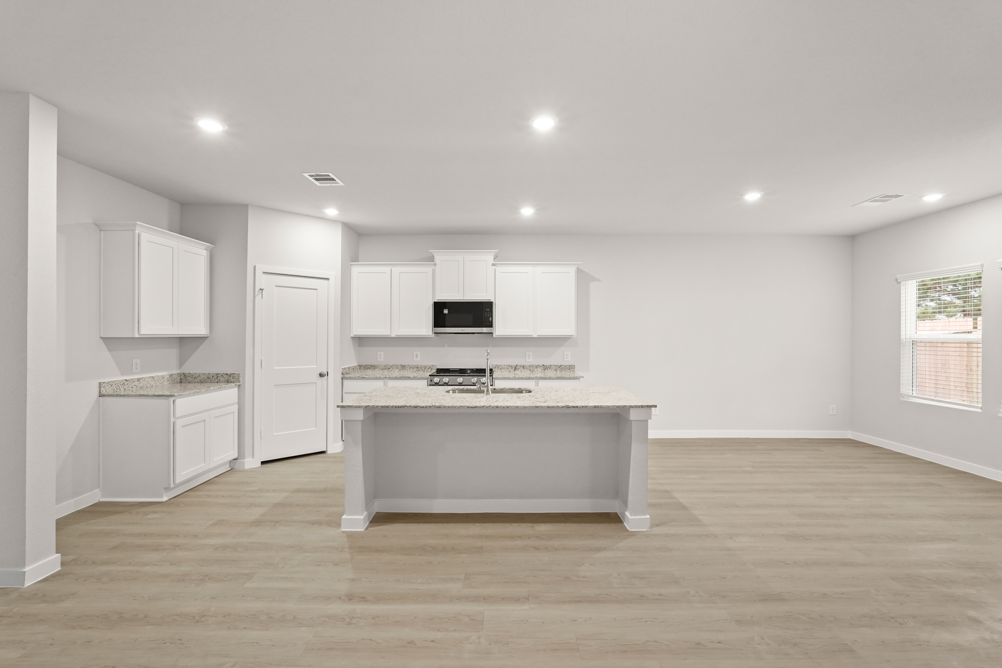 A kitchen with white cabinets.