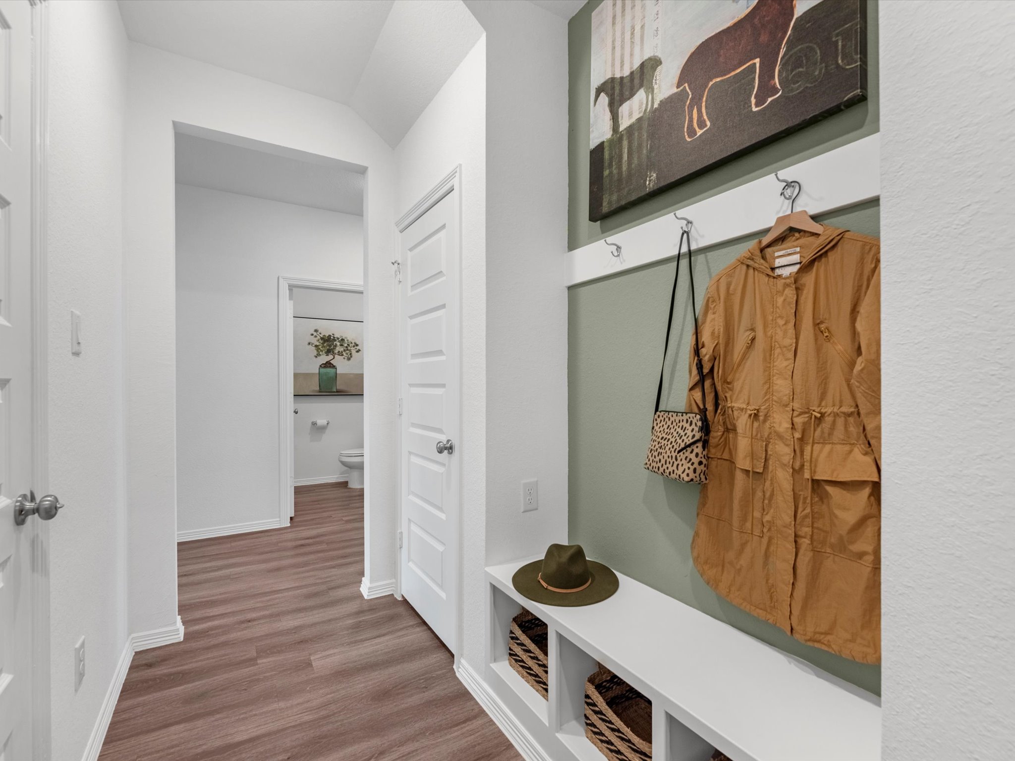 A bathroom with a hat and a coat rack.