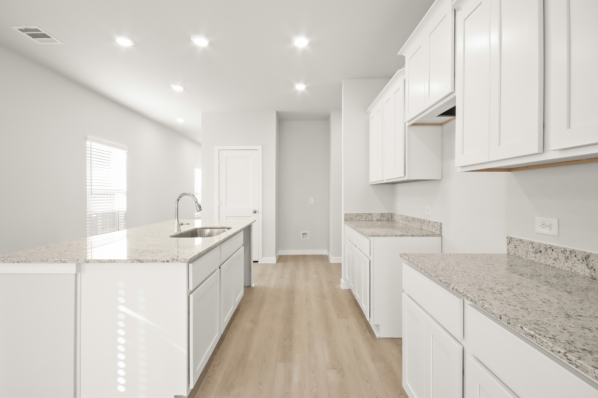 A kitchen with white cabinets.