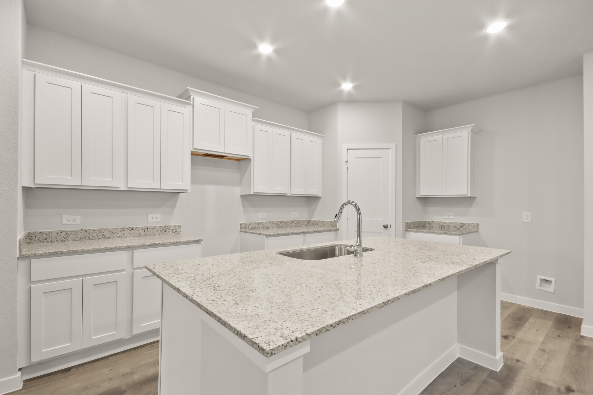 A kitchen with white cabinets.