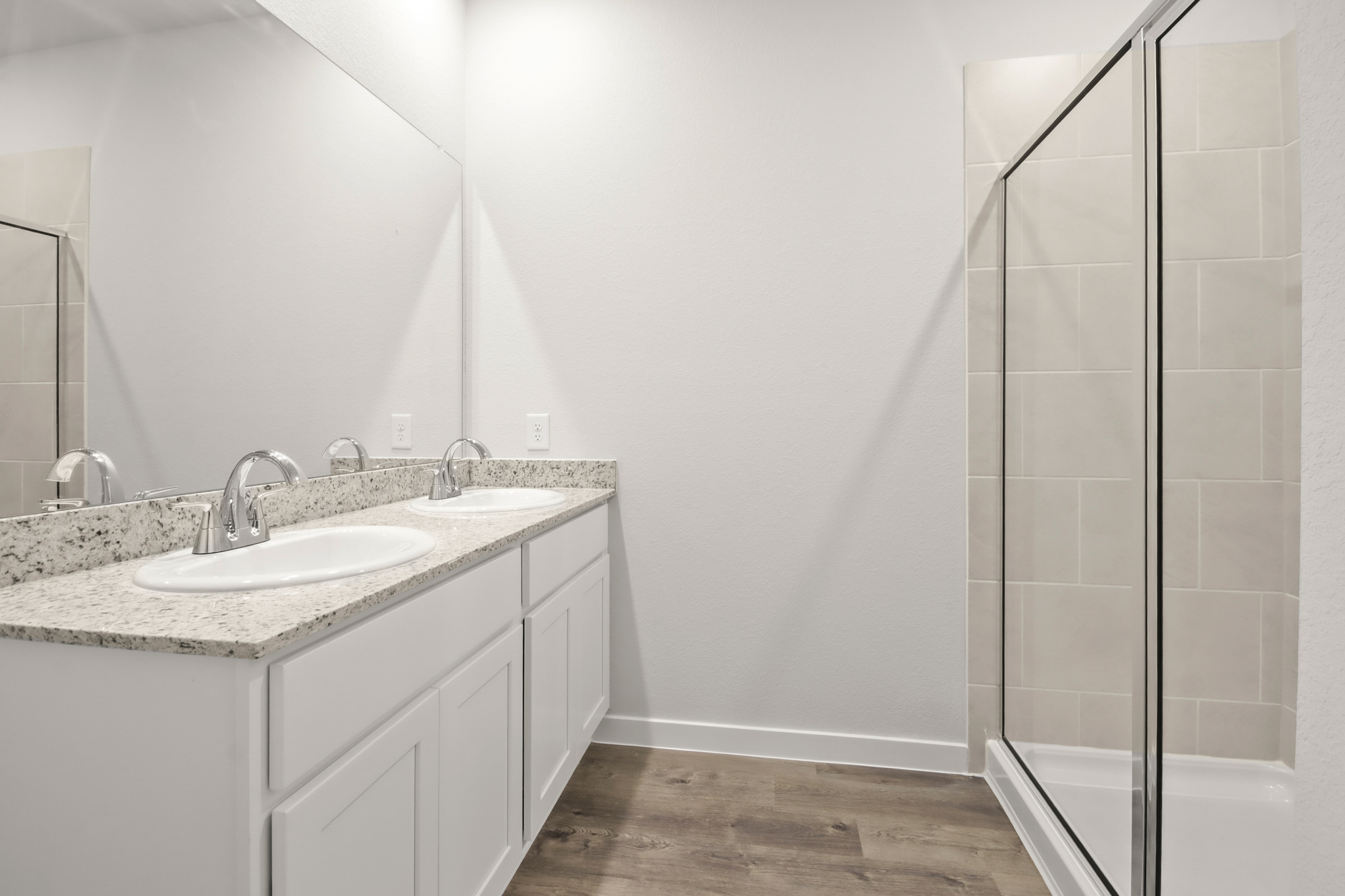 A bathroom with a sink and a shower unit.