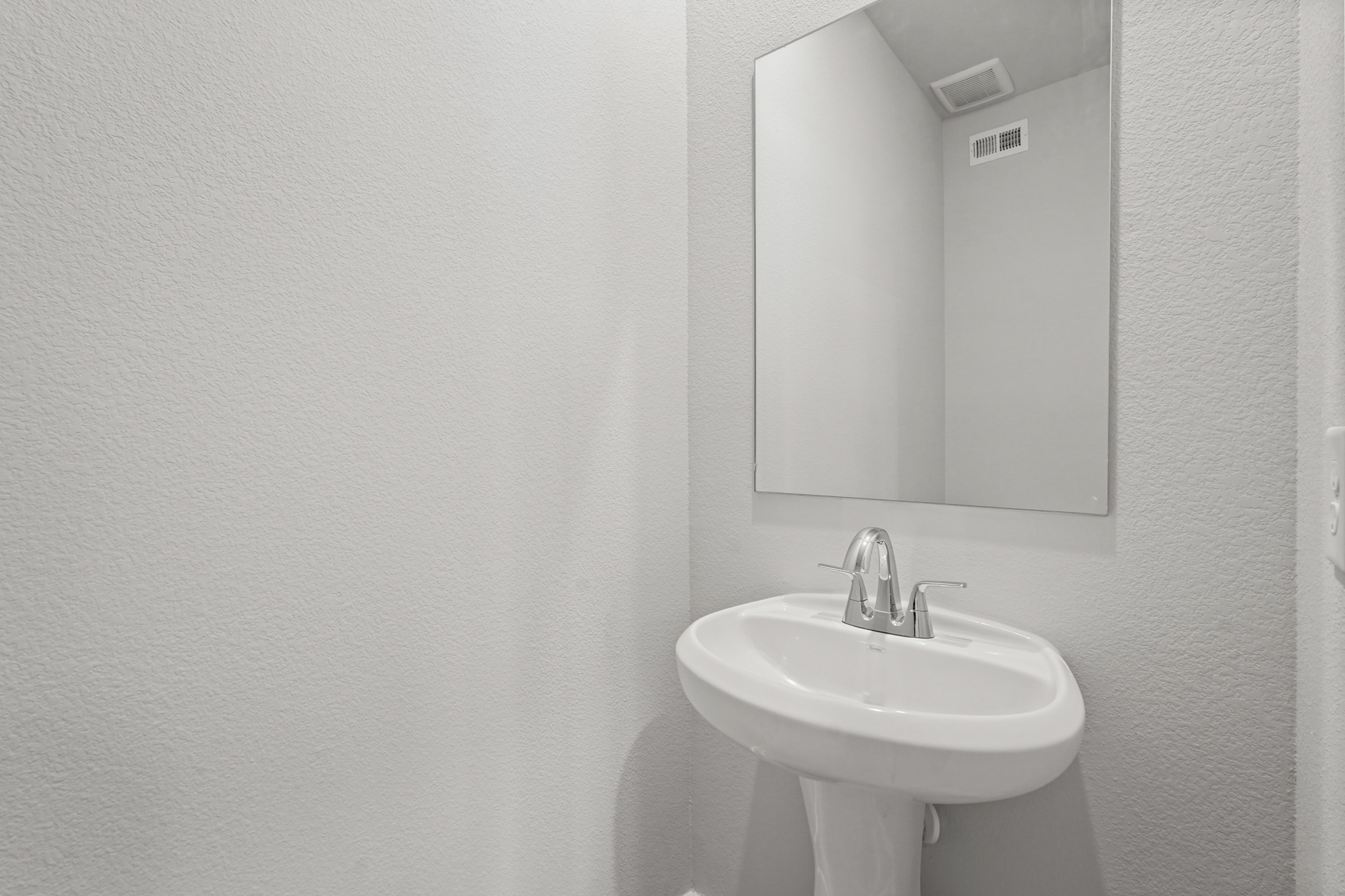 A bathroom with a mirror and sink.