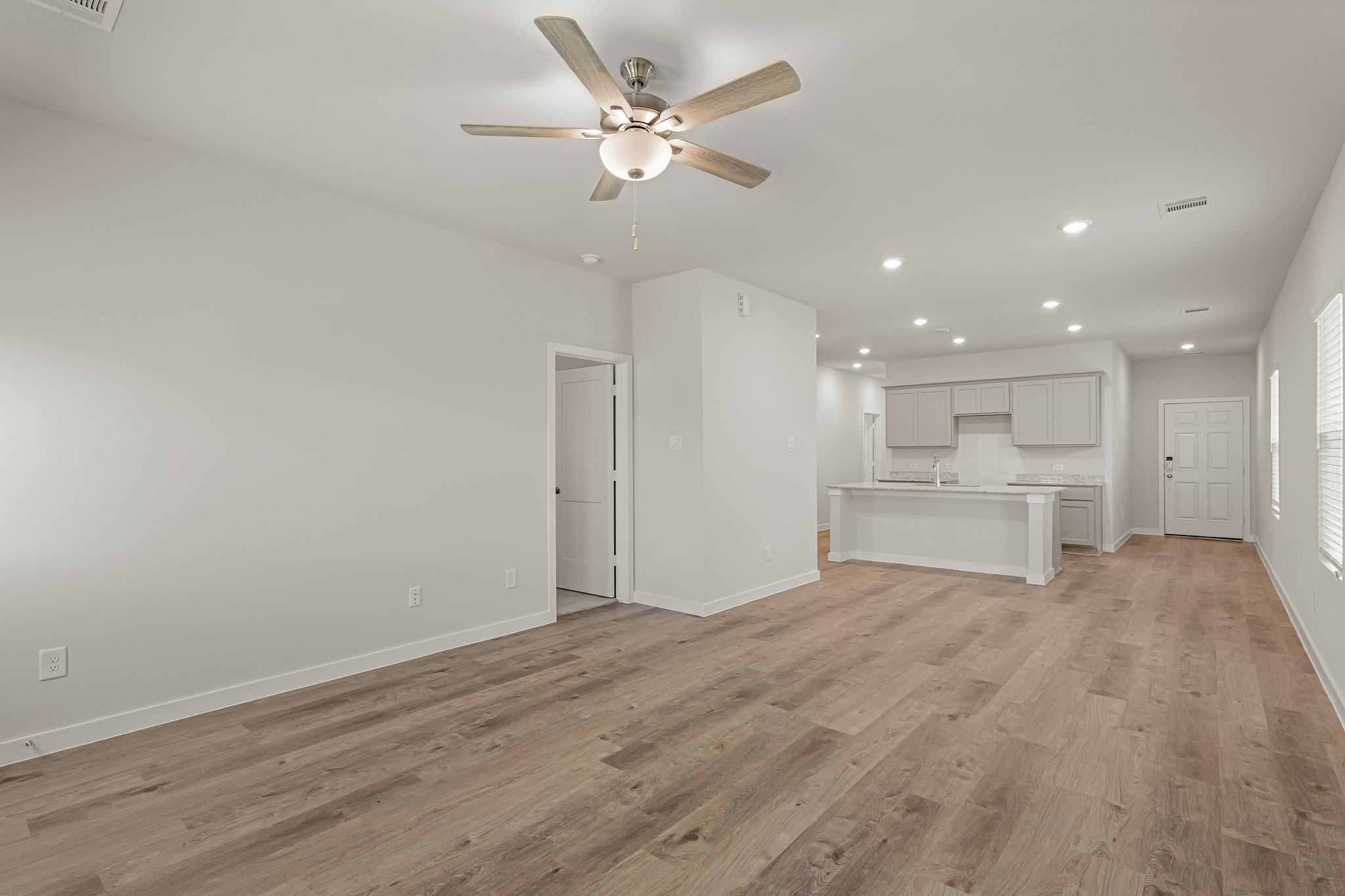 A room with a wood floor and a ceiling fan.