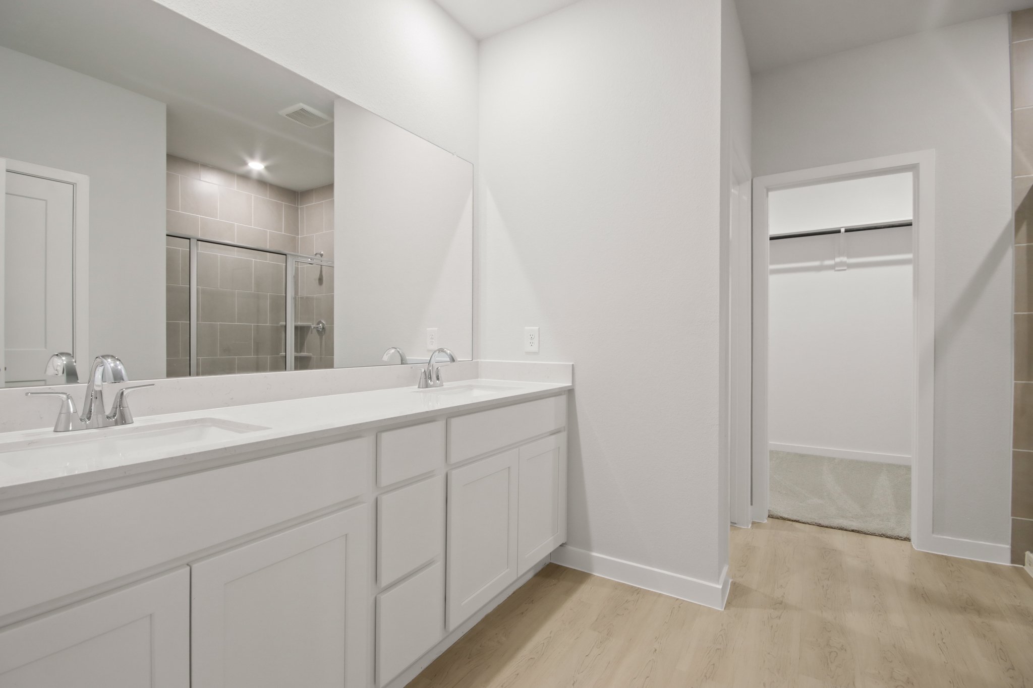 A bathroom with white cabinets.