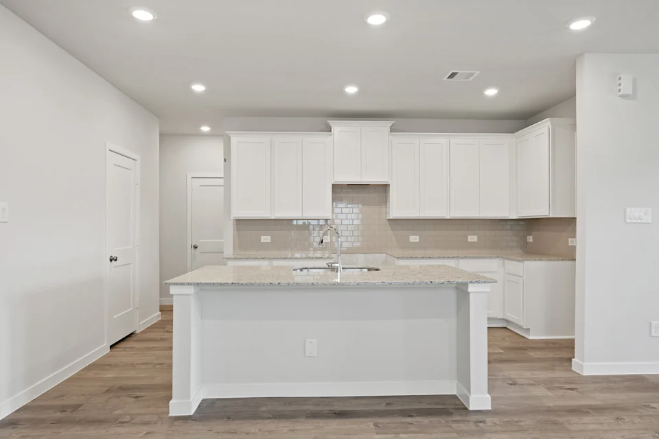 A kitchen with white cabinets.