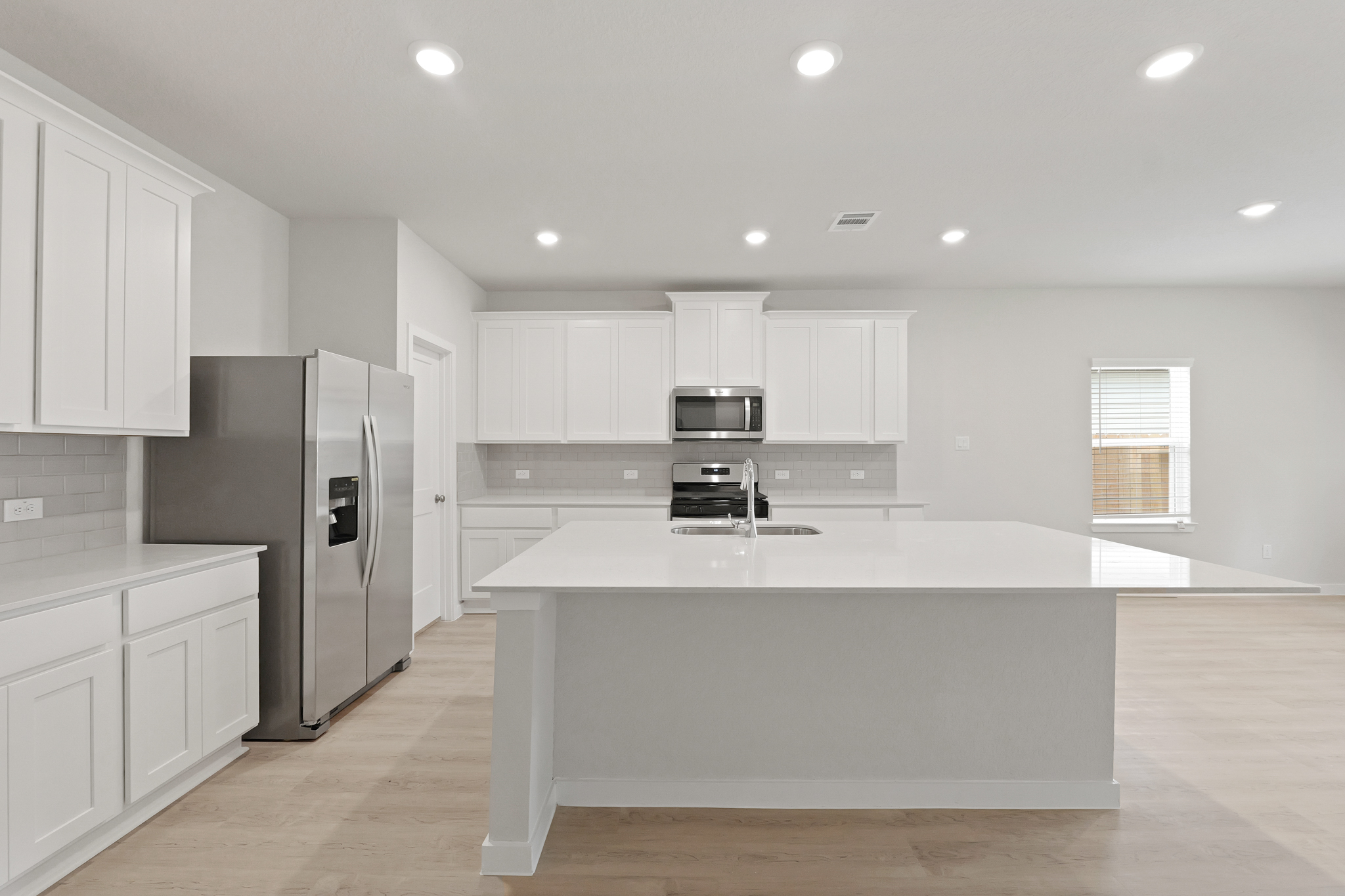 A kitchen with white cabinets.