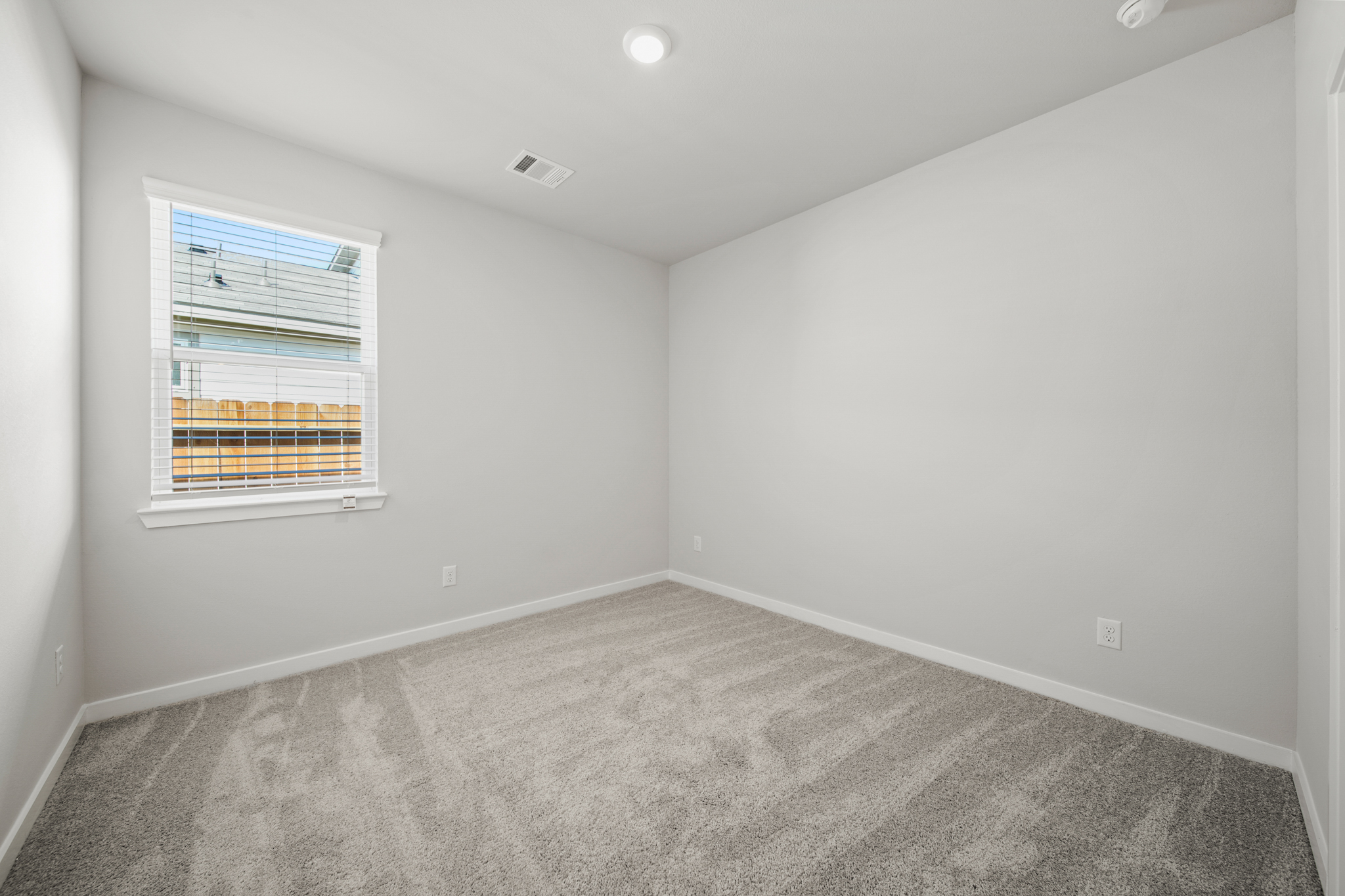 A room with a window and a carpet.