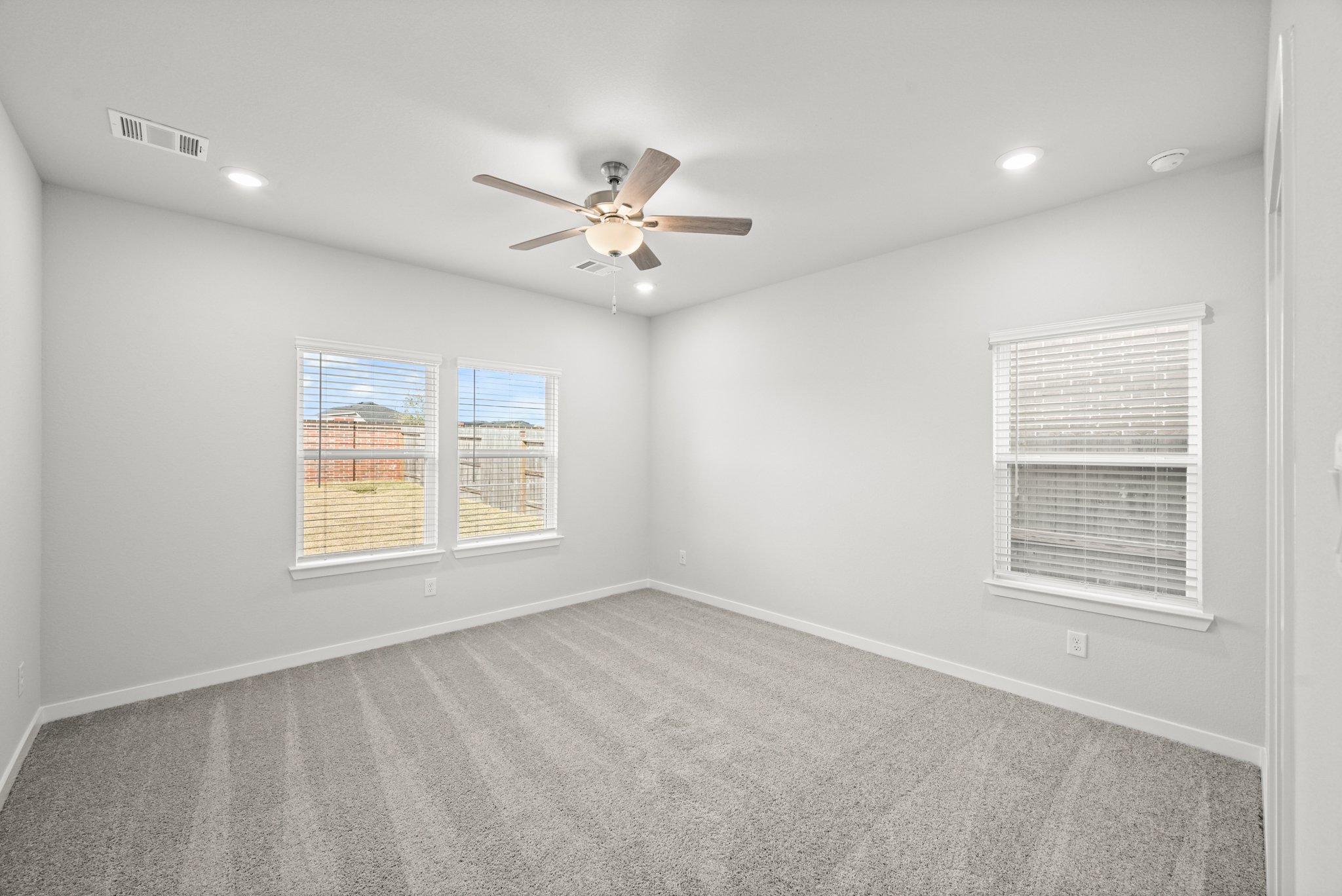 A room with a ceiling fan and a window.