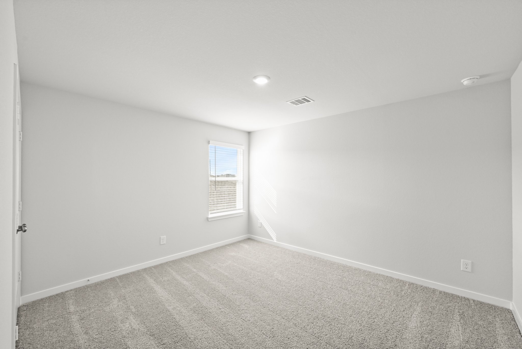 A room with a carpet and a window.