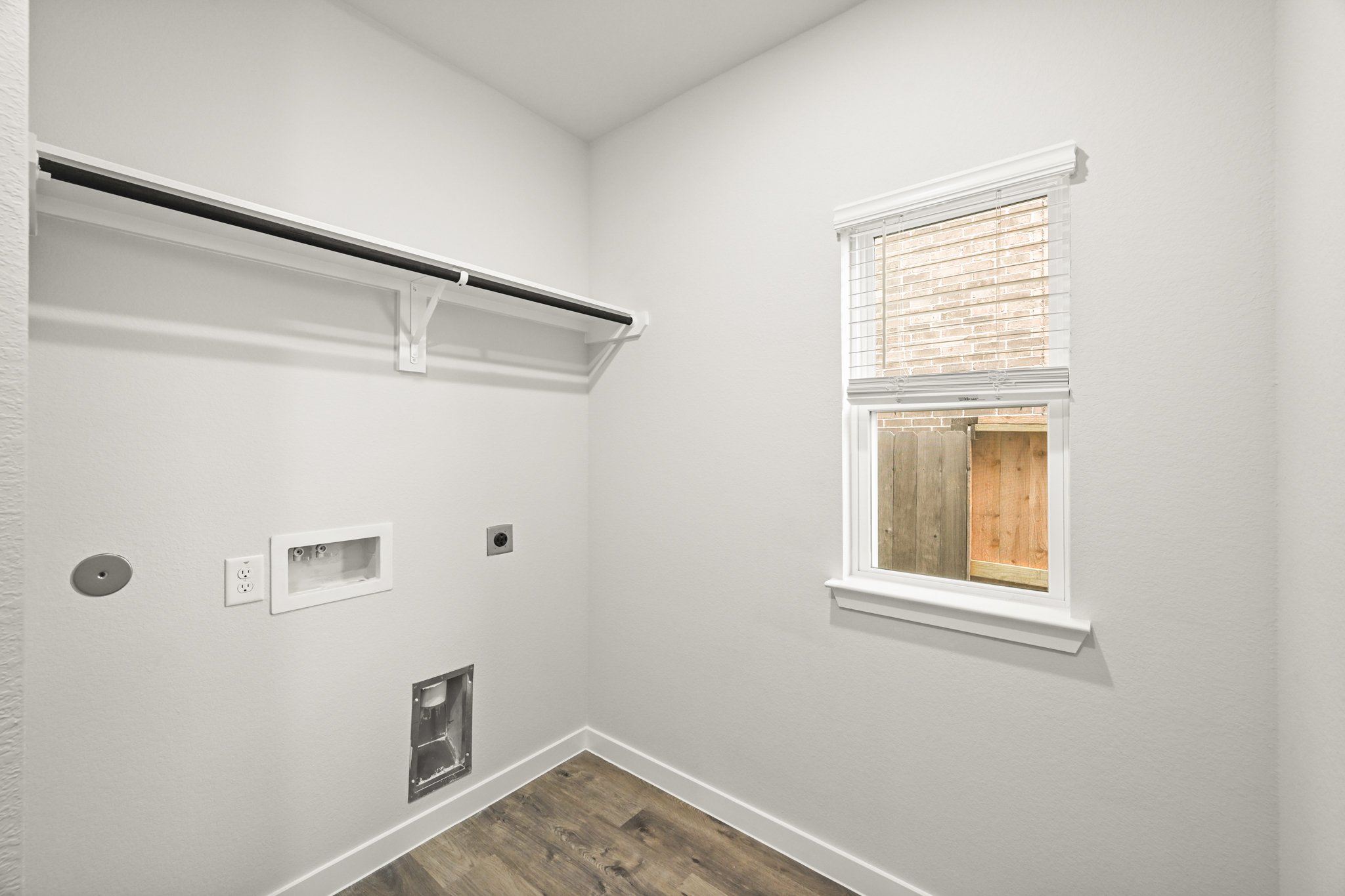 A room with a window and a wood floor.