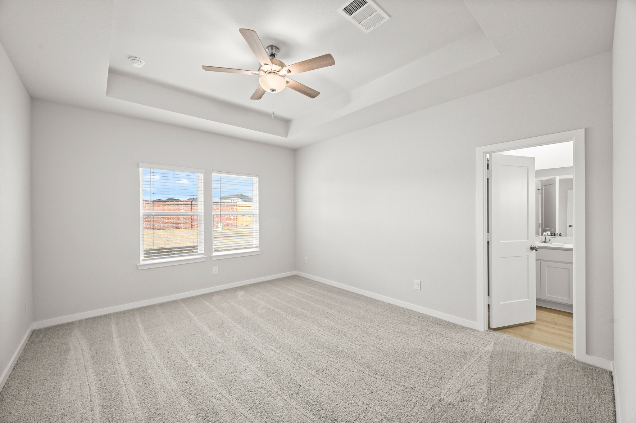 A room with a ceiling fan and a window.