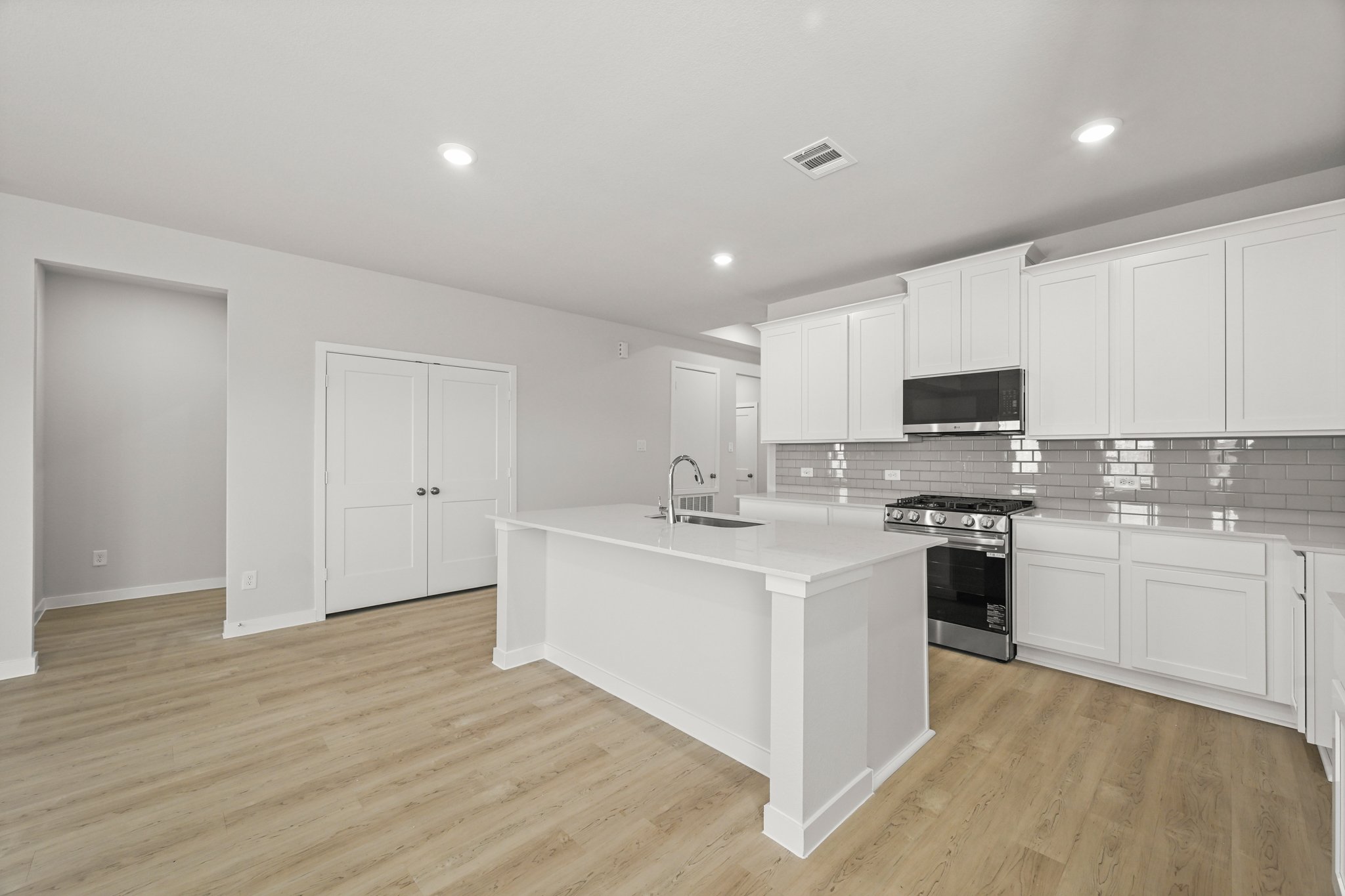 A kitchen with white cabinets.