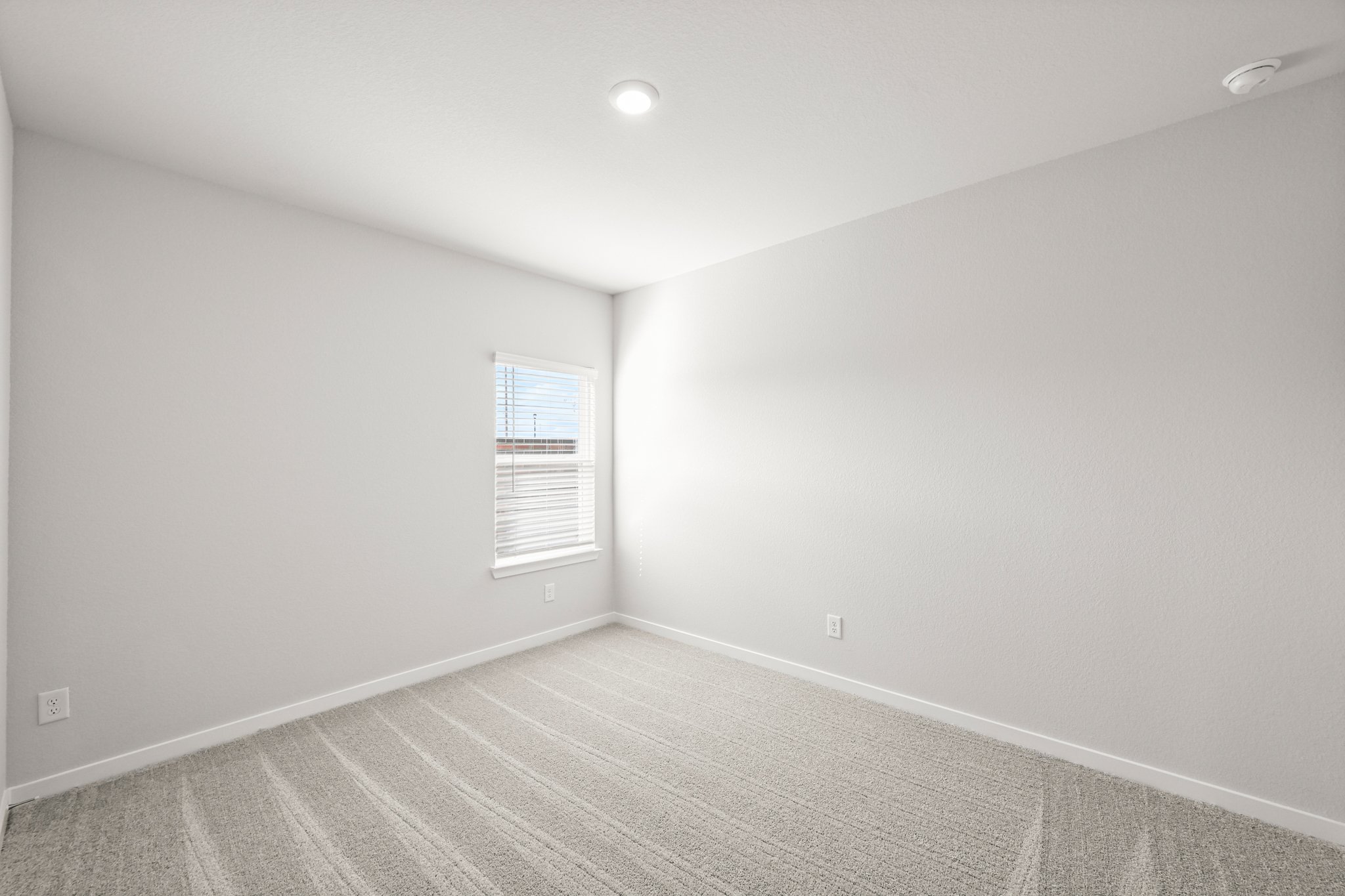 A room with a white wall and a window.