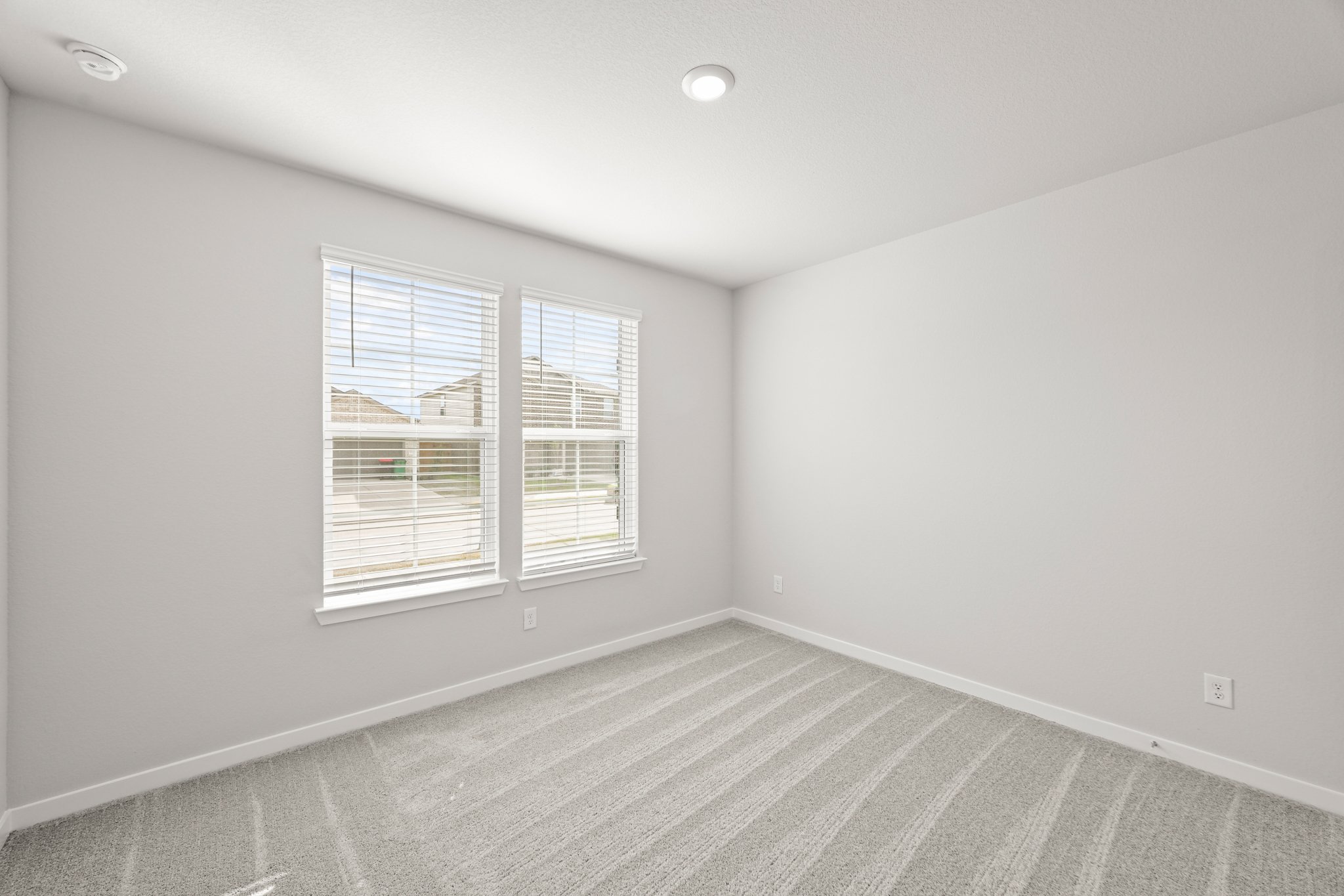 A room with a window and a rug.