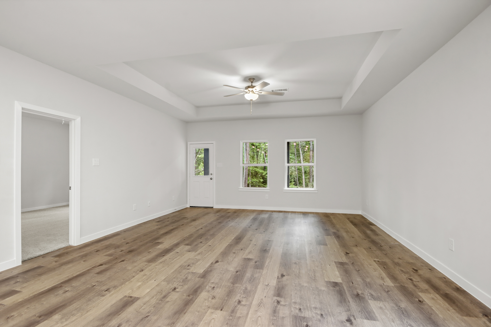A room with a wood floor and a ceiling fan.