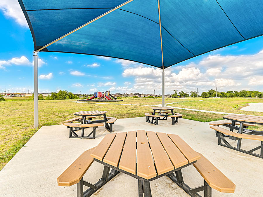 A group of picnic tables on a wood deck.