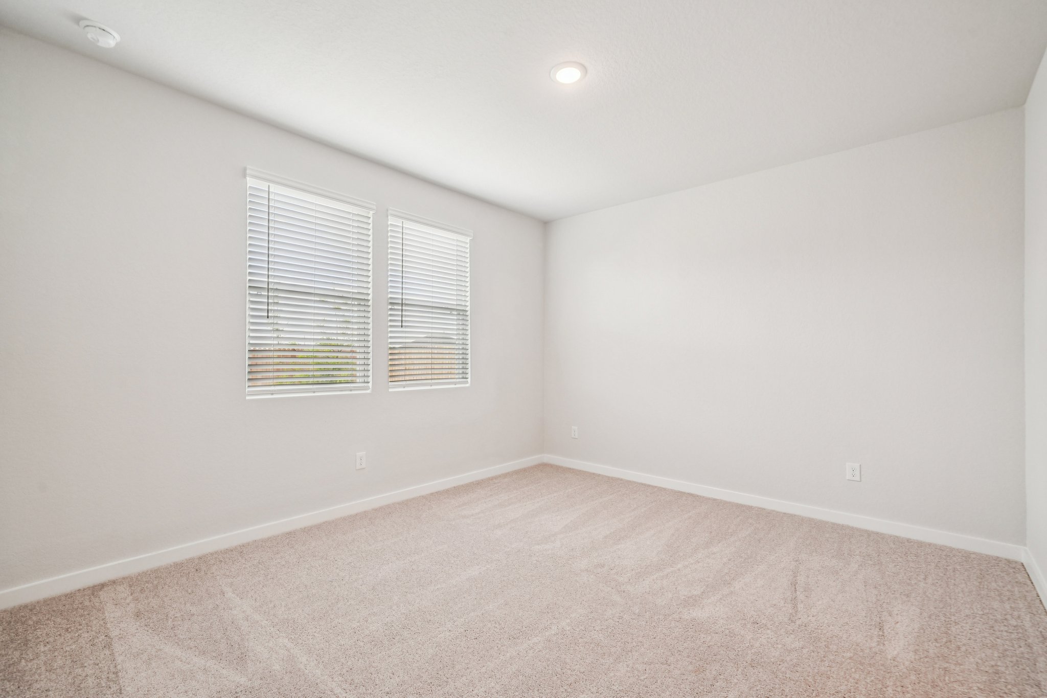 A room with a carpet and a window.