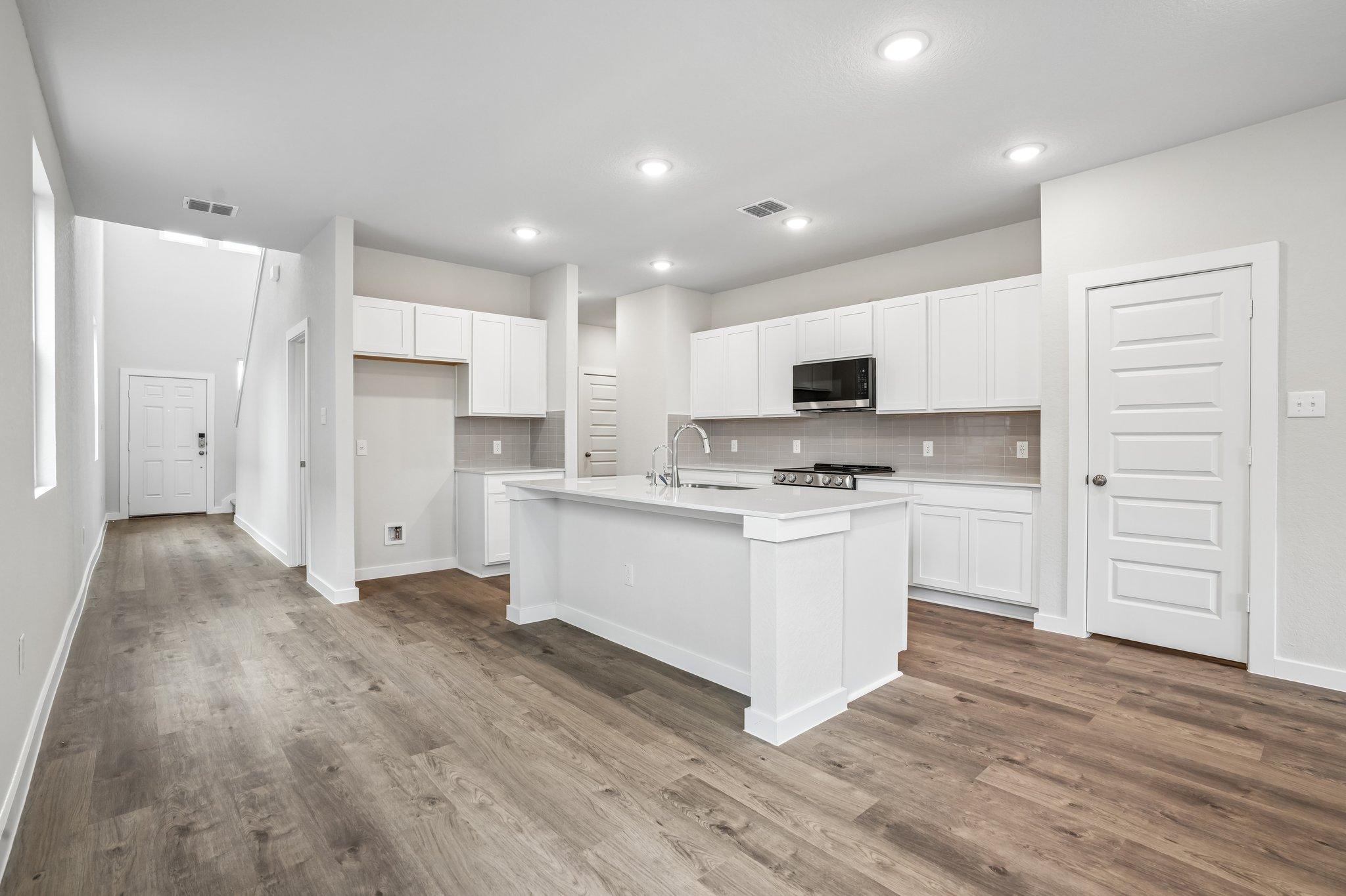 A kitchen with white cabinets.