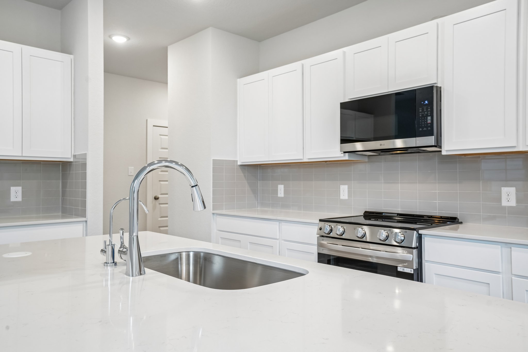 A kitchen with white cabinets.