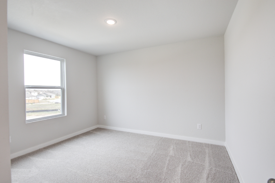 A room with a window and a carpet.