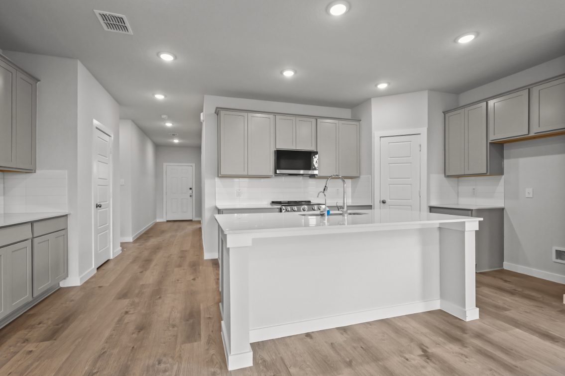 A kitchen with white cabinets.