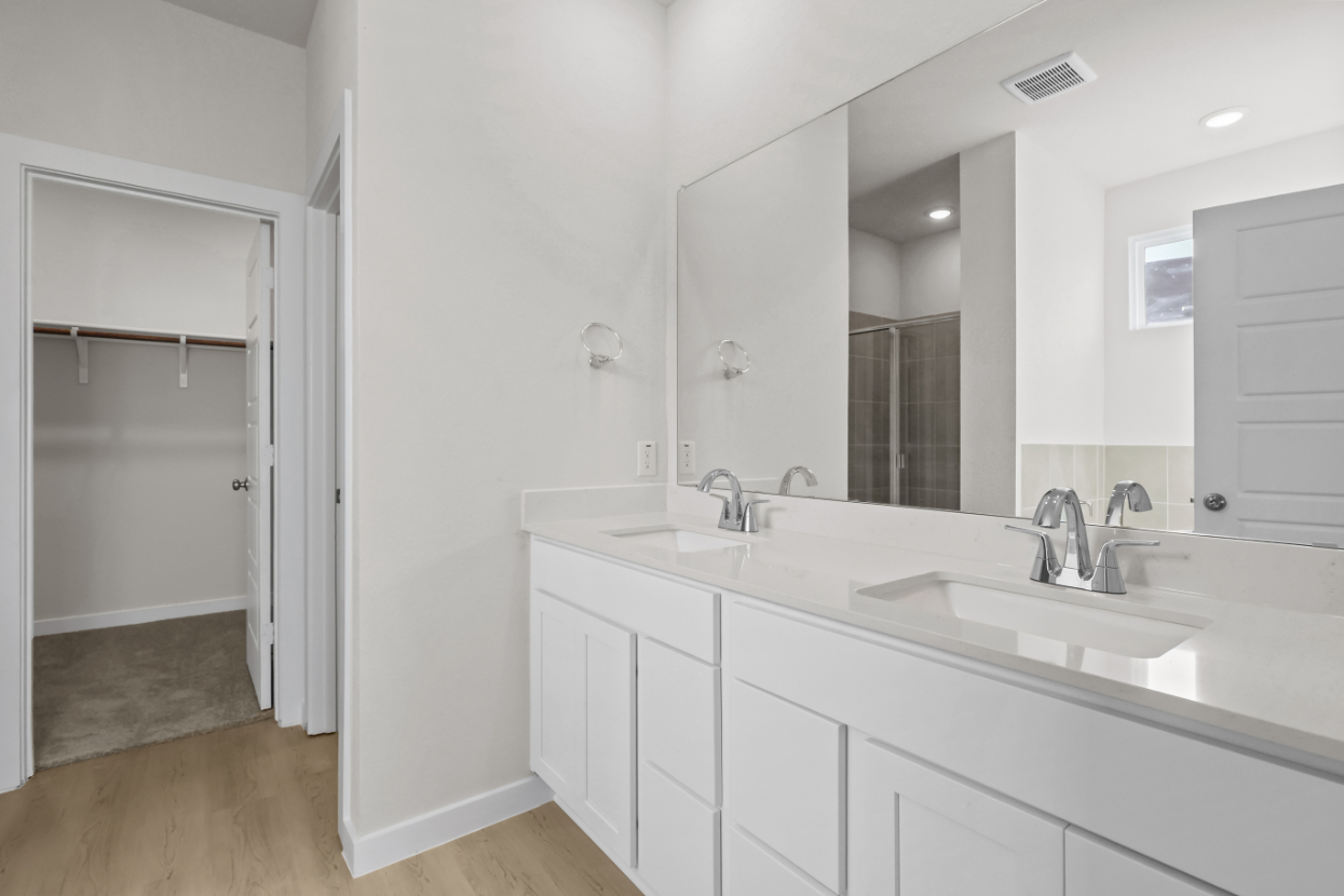 A bathroom with white cabinets.