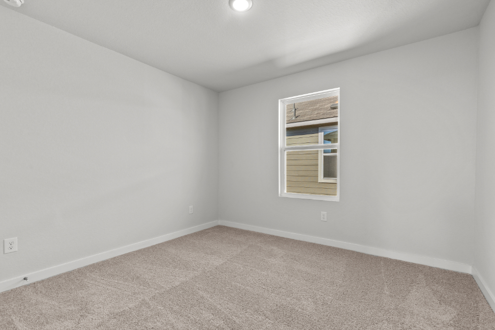 A room with a window and carpet.