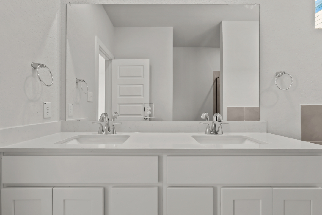 A bathroom with white cabinets.