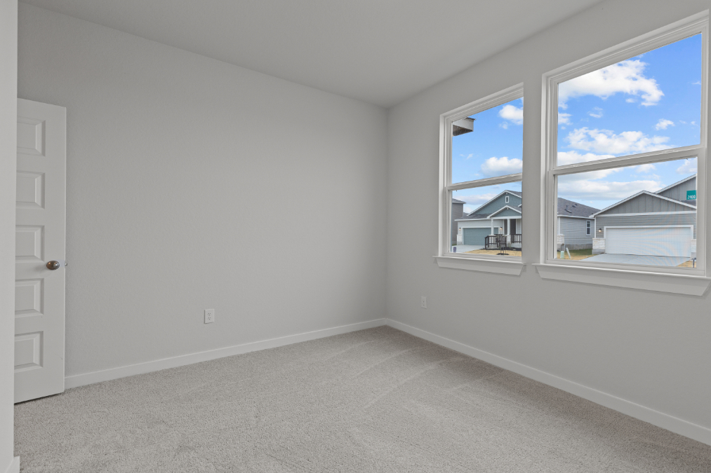 A room with a window and a door with a view of the city.