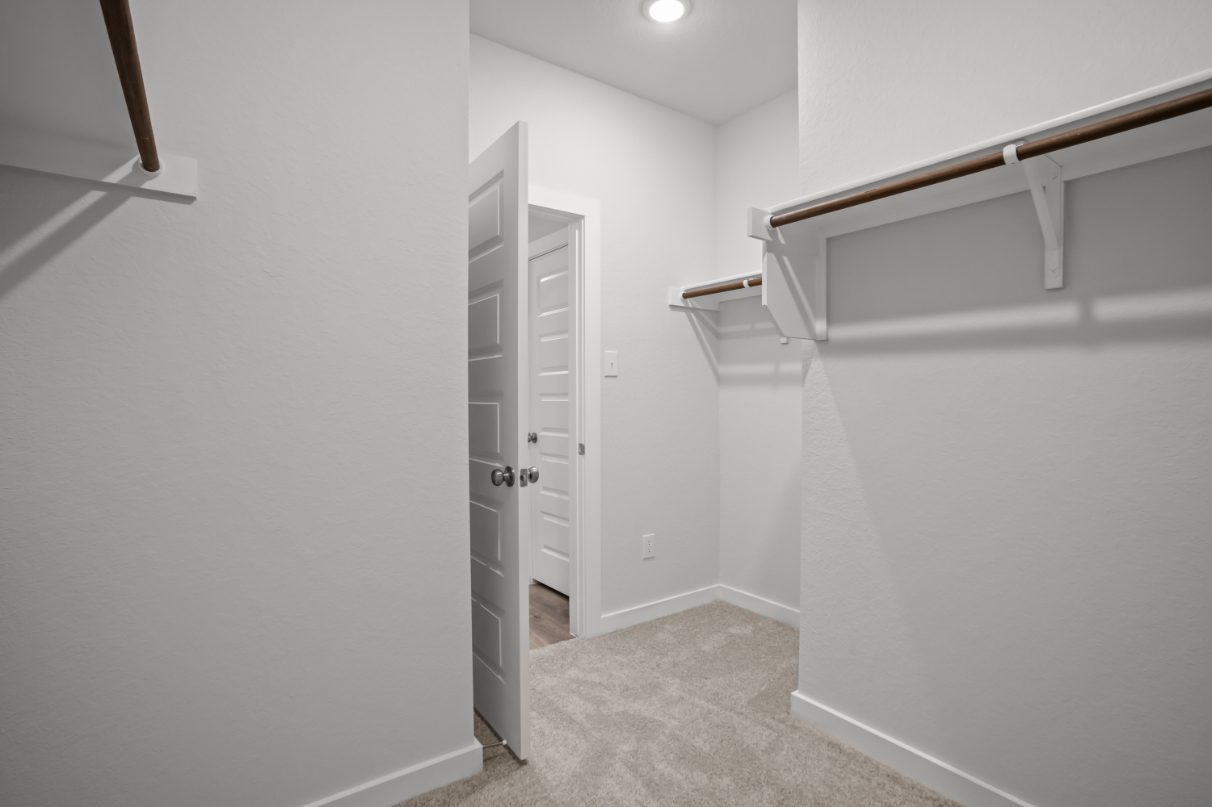 A white hallway with a metal railing.